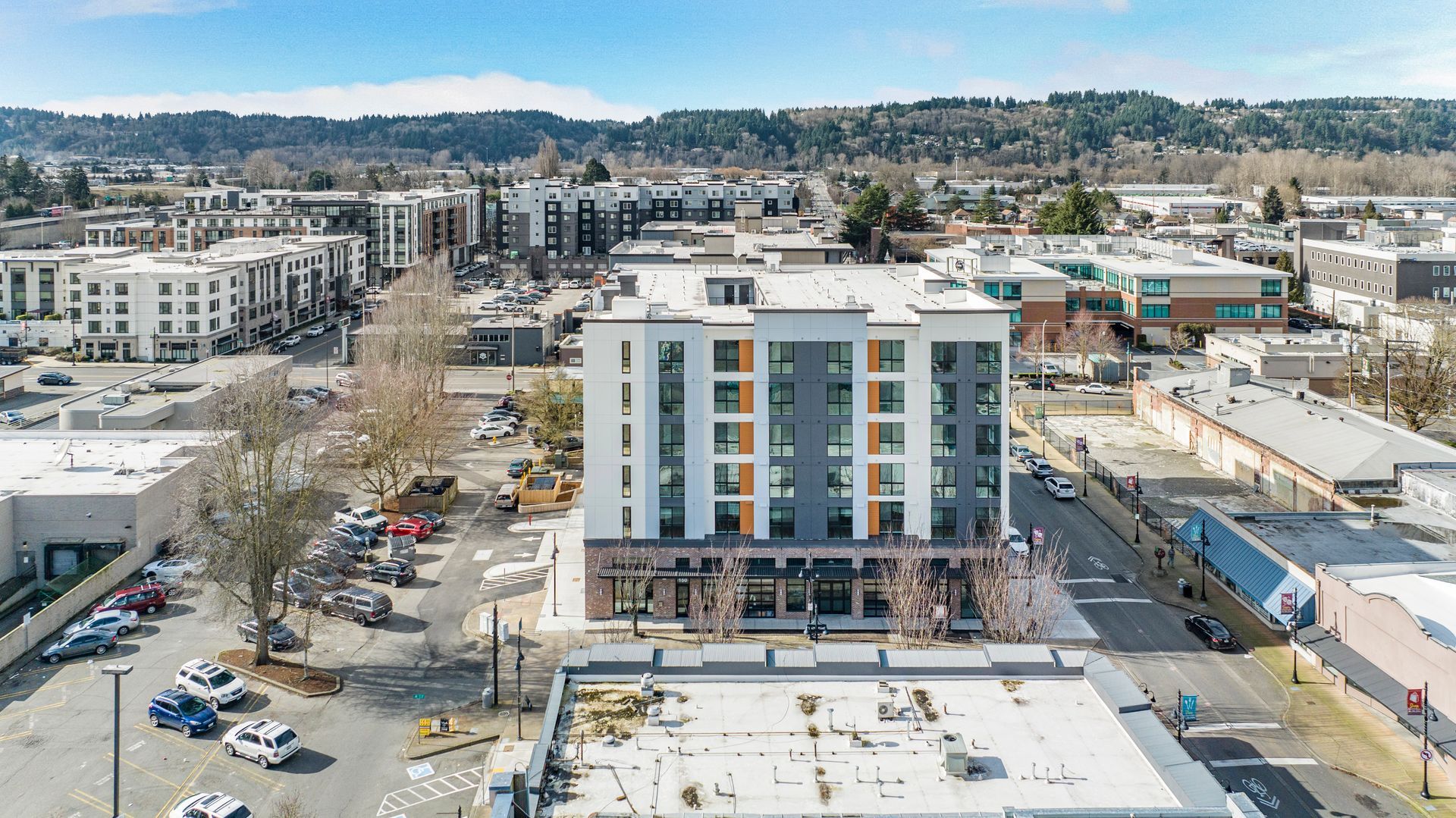 An aerial view of a city with a large building in the middle of it.