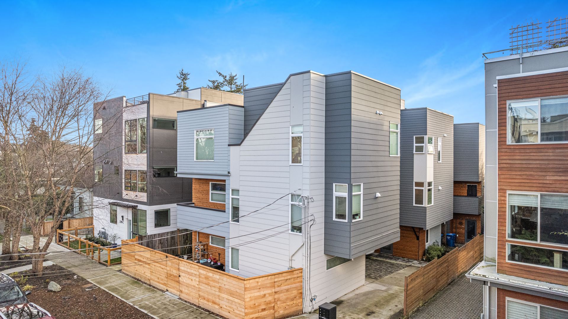 An aerial view of a row of apartment buildings with a wooden fence in front of them.