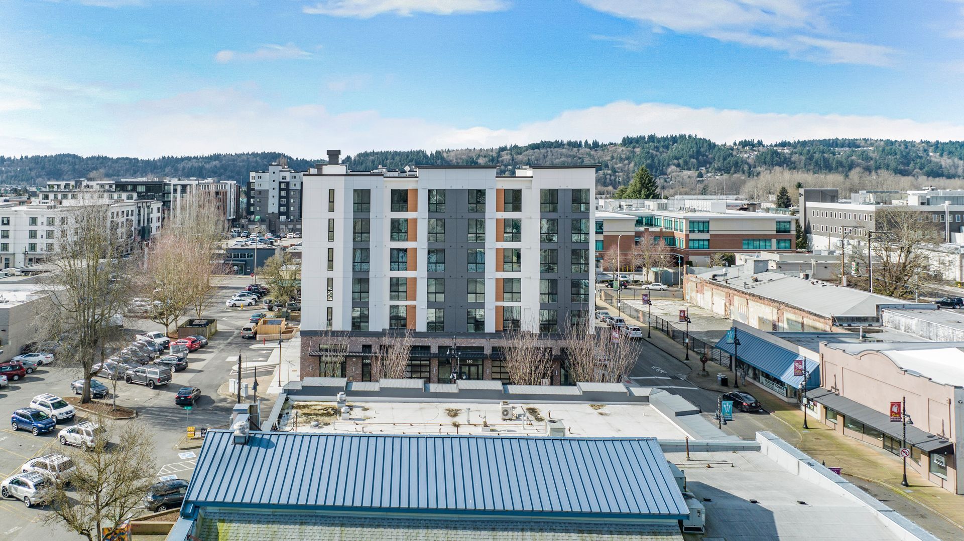 An aerial view of a building with a blue roof in a city.