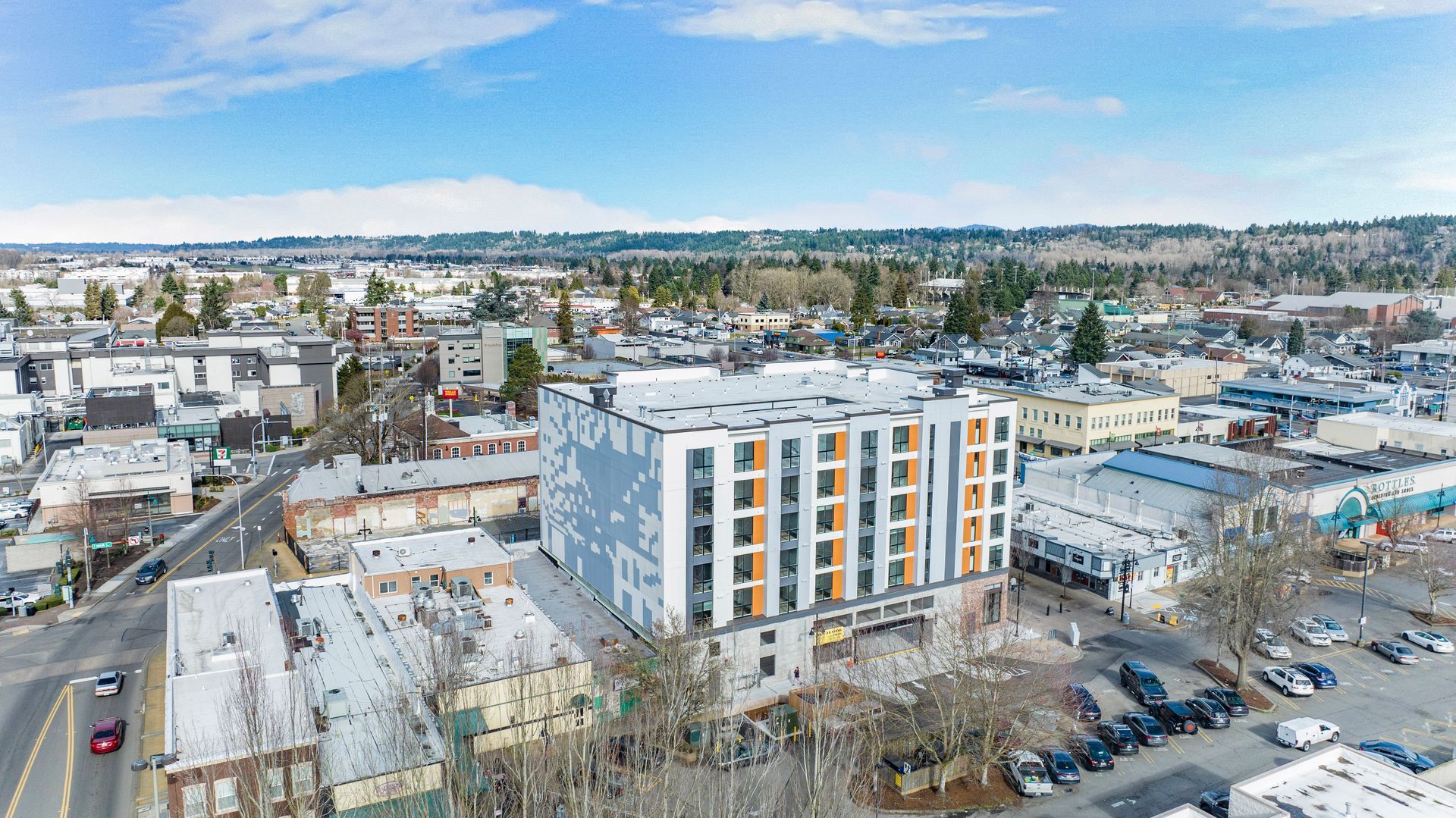 An aerial view of a city with a large building in the middle of it.