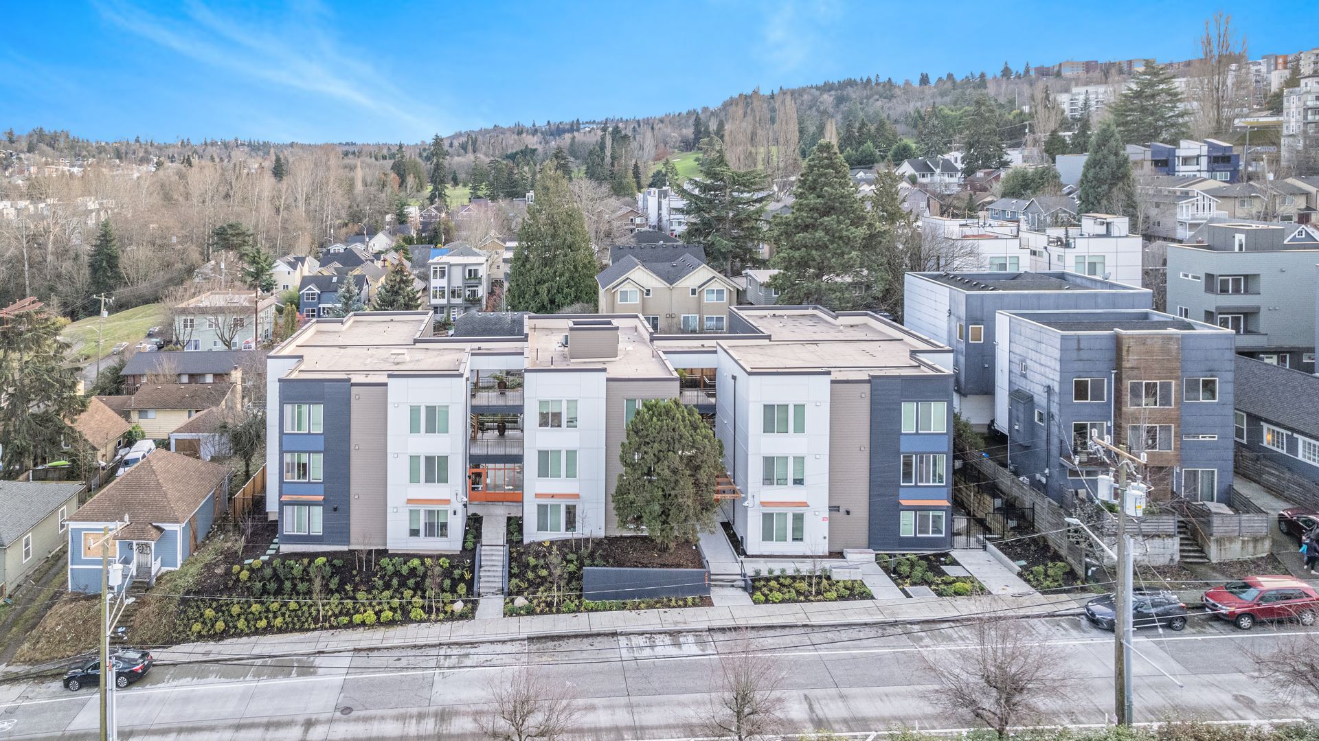 An aerial view of a large apartment building in a residential area.