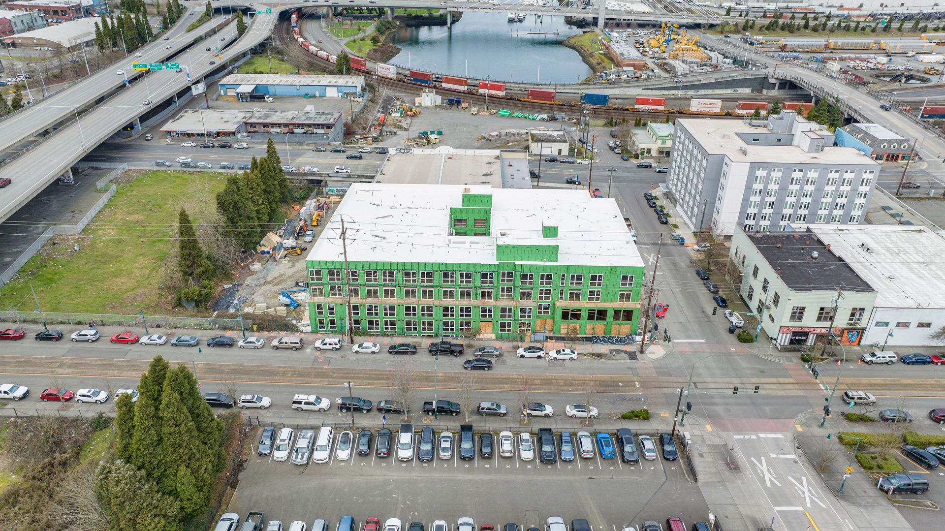 An aerial view of a city with a green building in the middle of it.