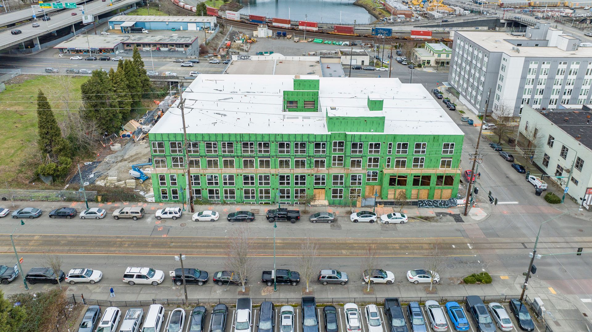 An aerial view of a building under construction with cars parked in front of it.