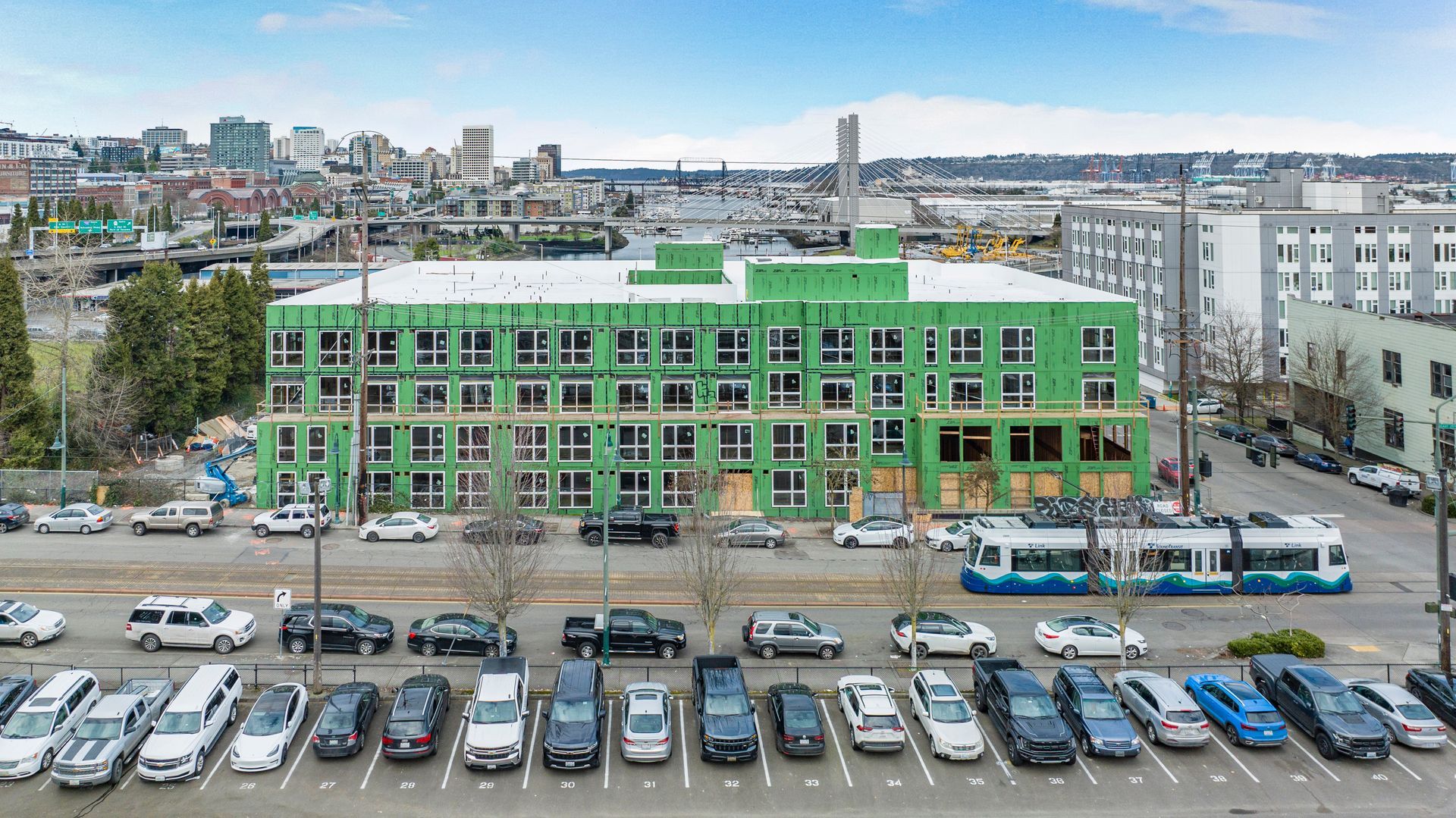 A large green building with a lot of cars parked in front of it.