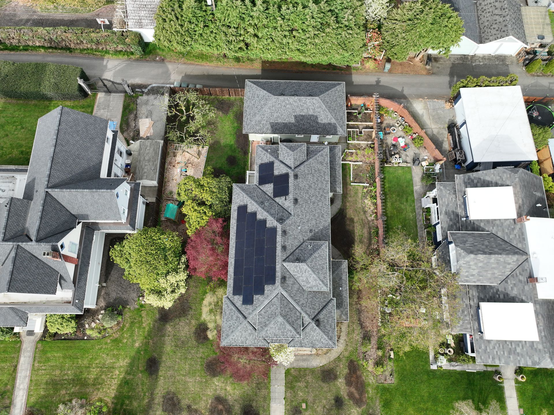An aerial view of a house with solar panels on the roof.