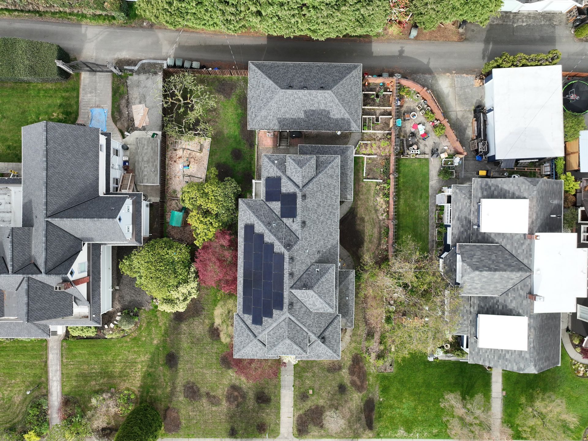 An aerial view of a house with solar panels on the roof.