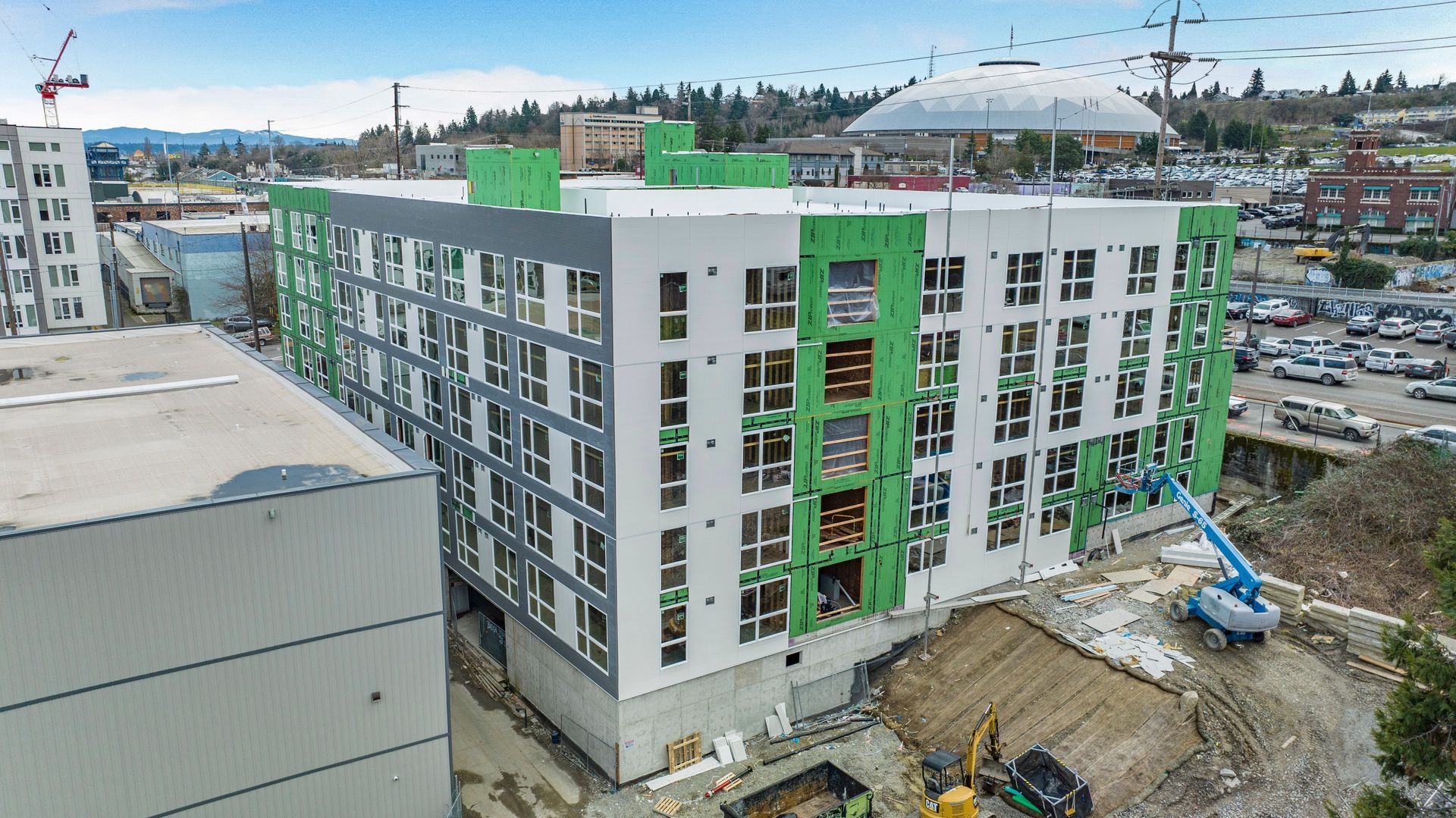 An aerial view of a large building under construction in a city.