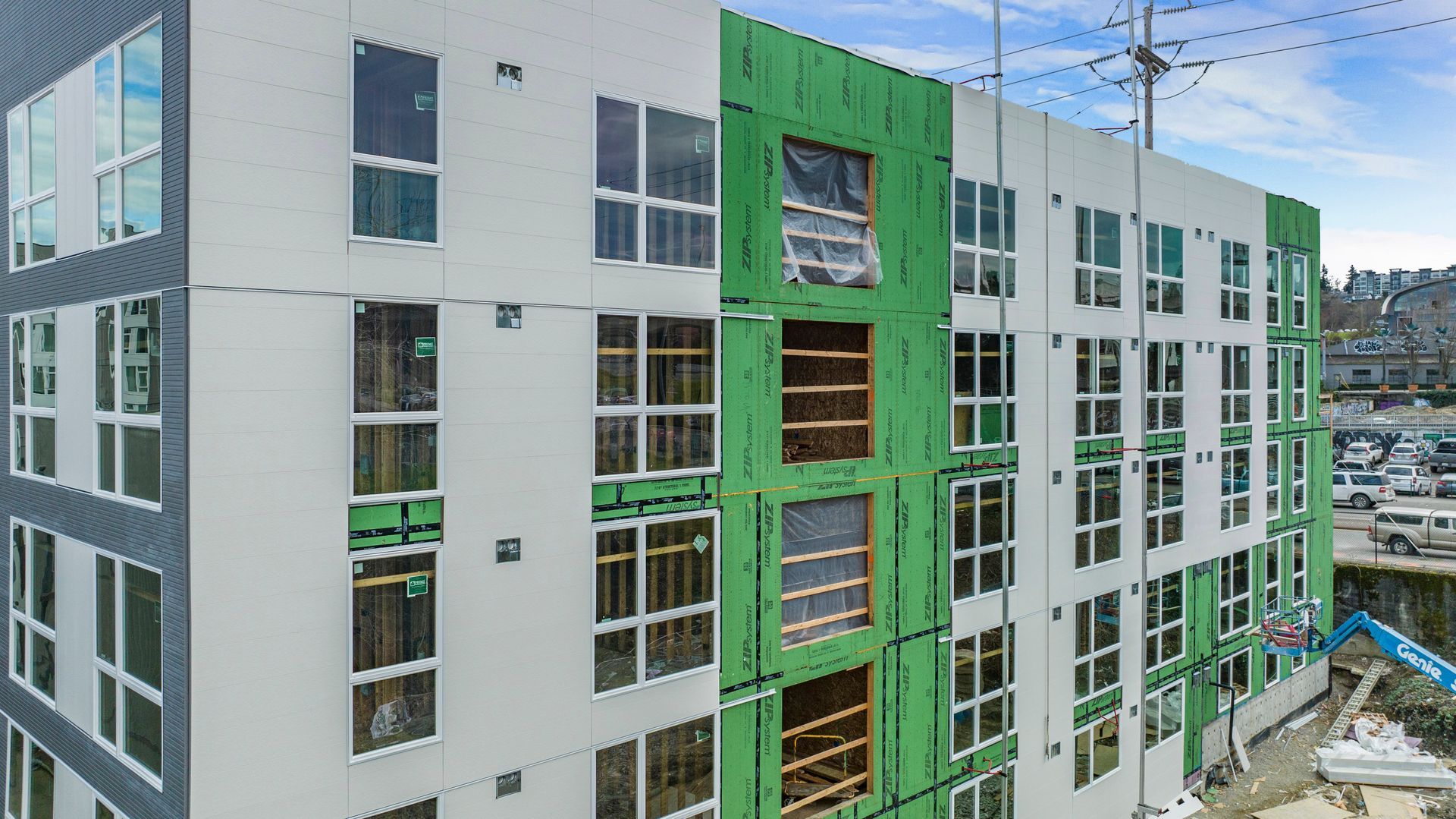An aerial view of a building under construction with green windows.