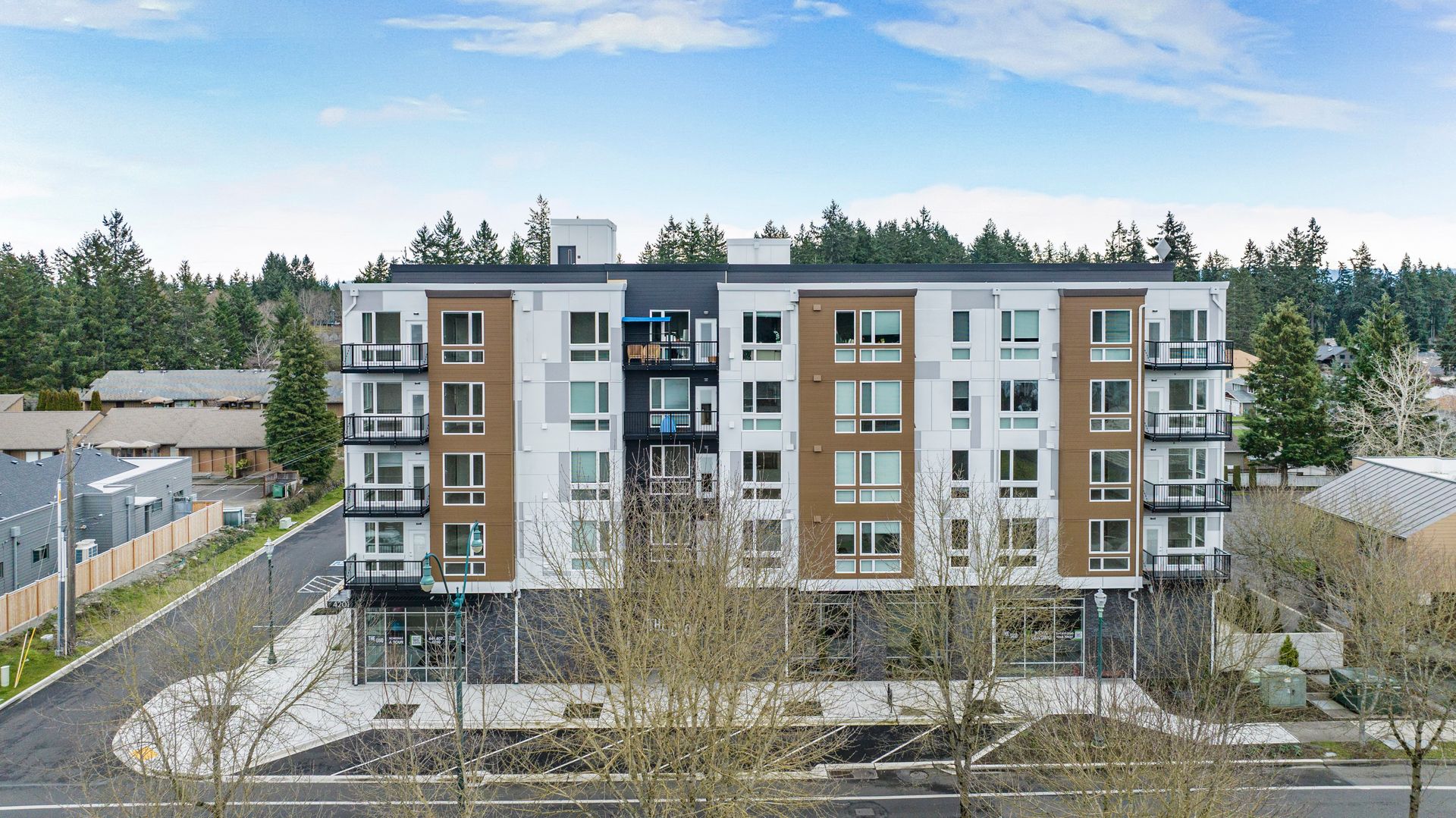 An aerial view of a large apartment building with trees in the background.