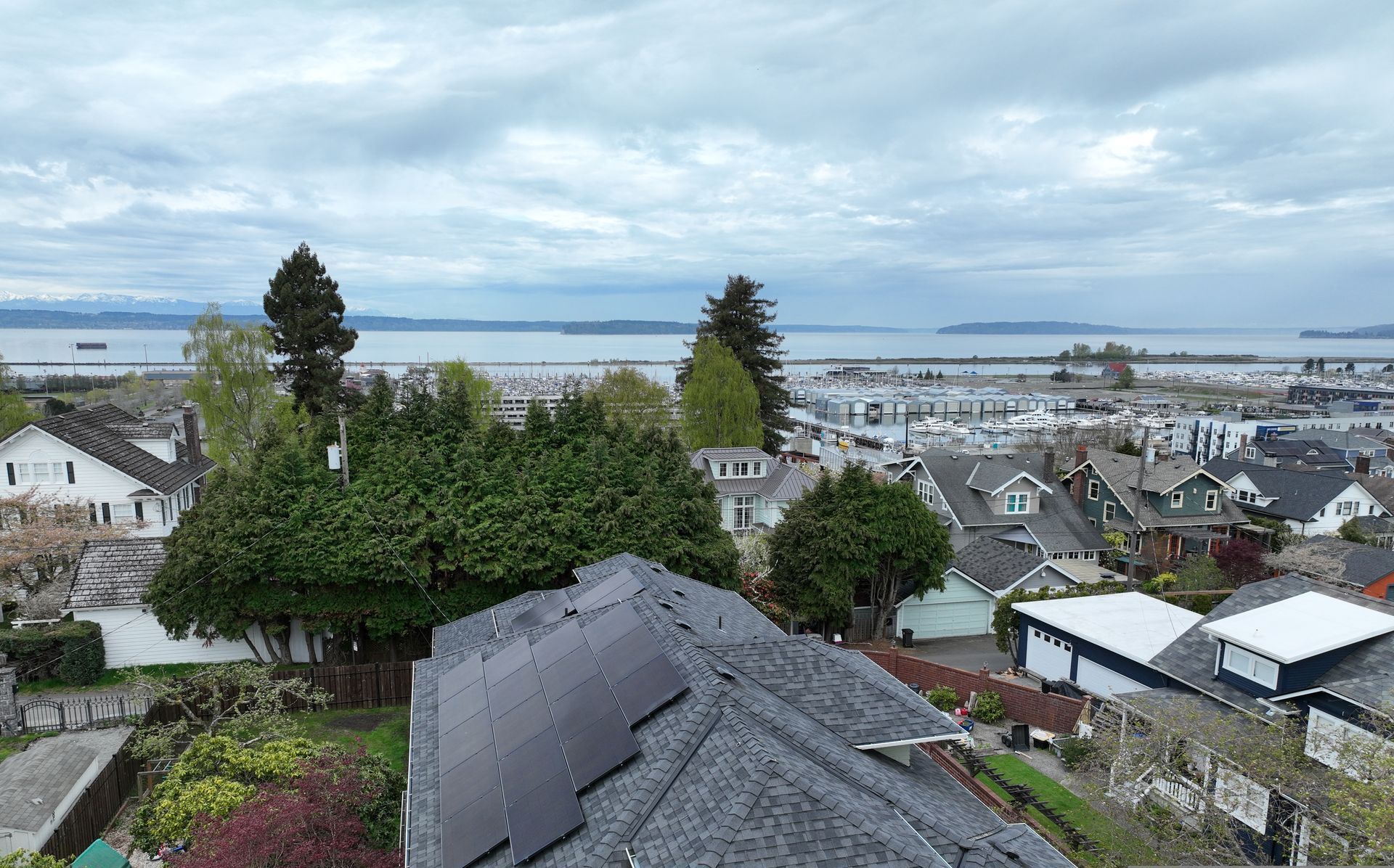 An aerial view of a residential area with a large body of water in the background.