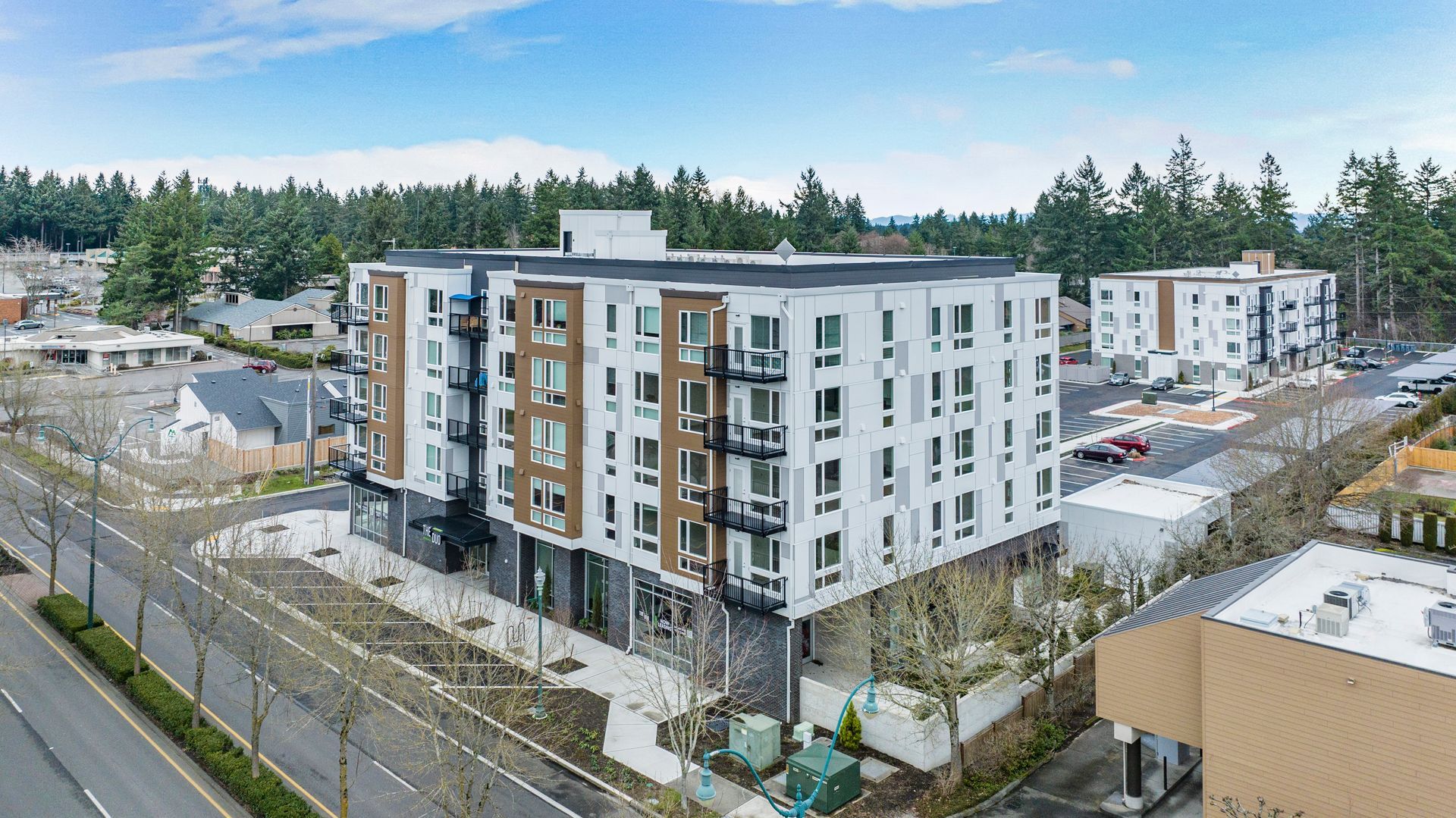 An aerial view of a large apartment building next to a road.