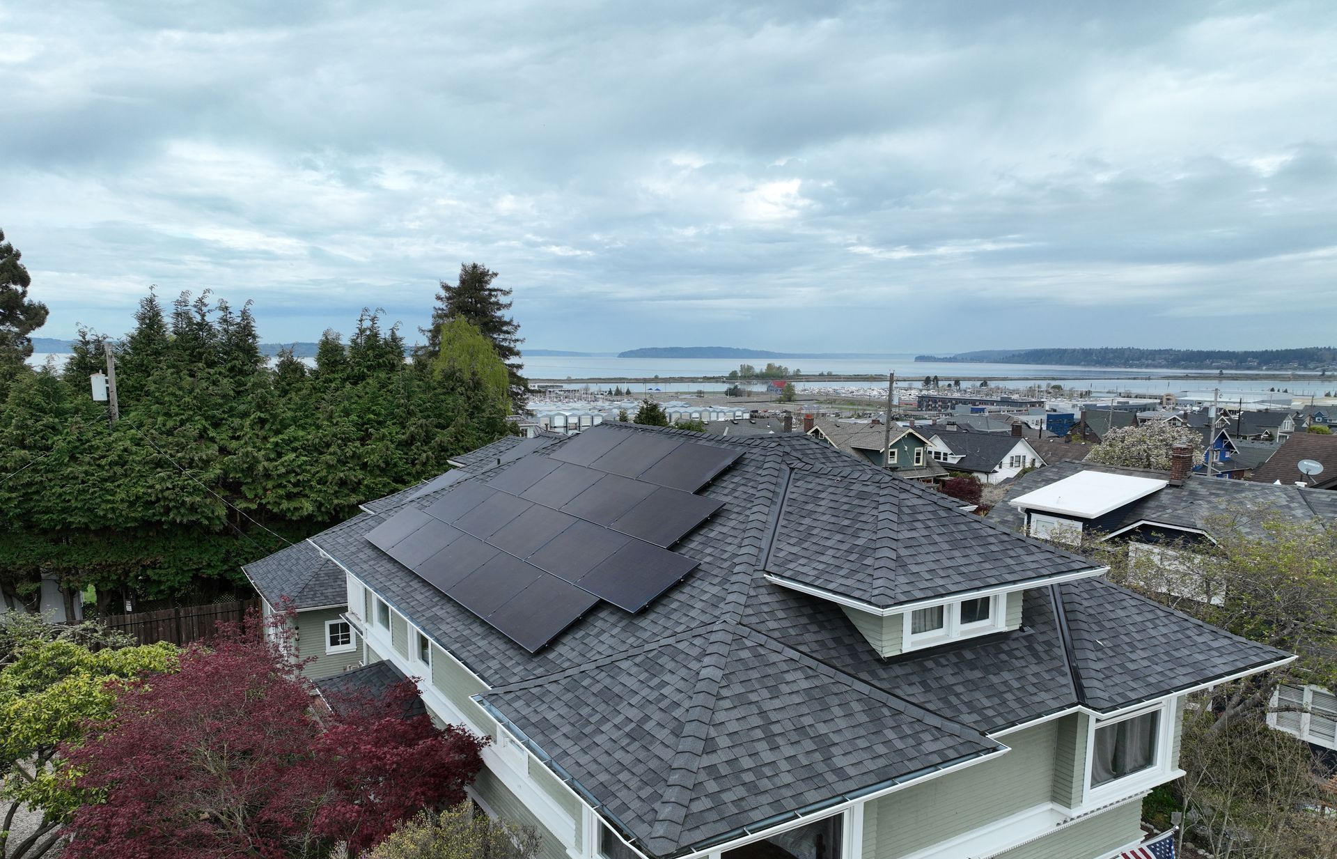 An aerial view of a house with solar panels on the roof.