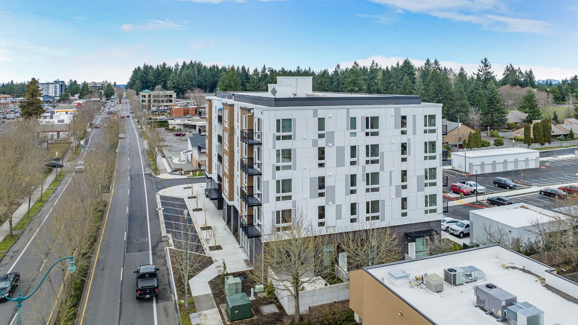 An aerial view of a large apartment building next to a road.