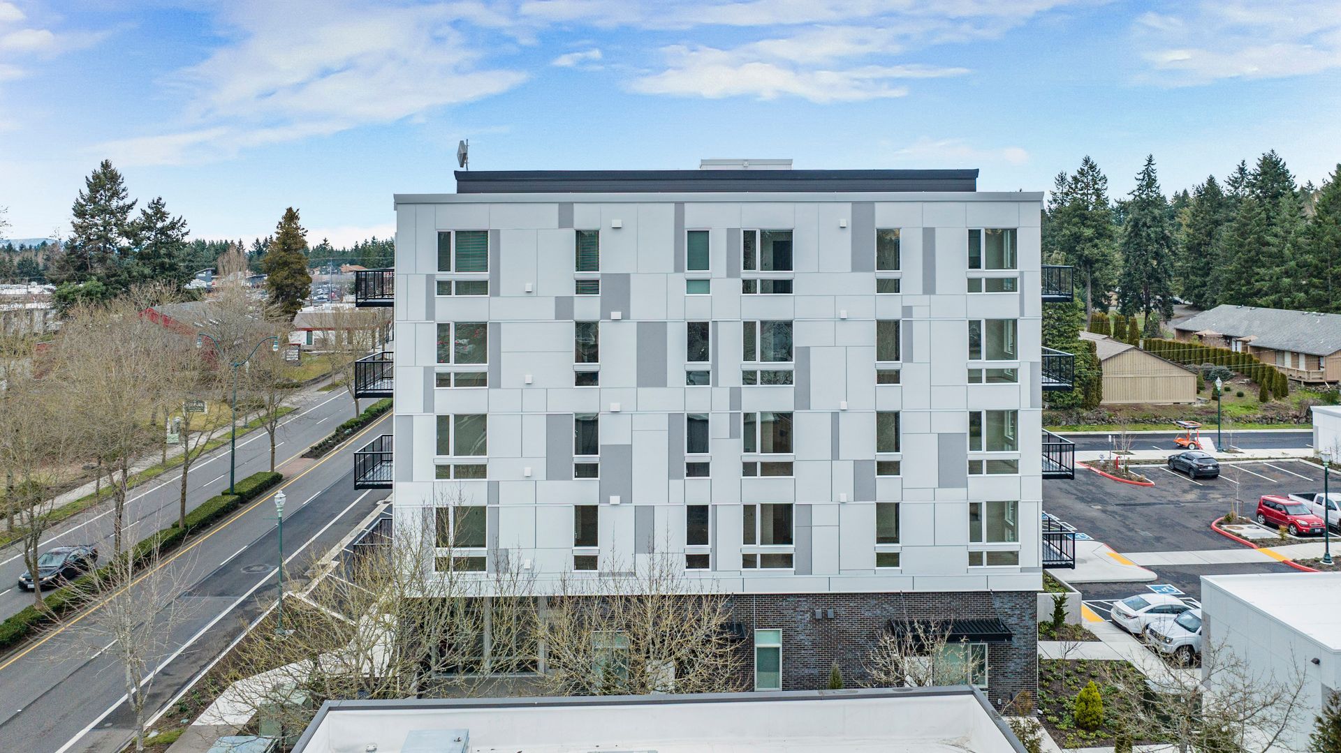 An aerial view of a large apartment building next to a road.