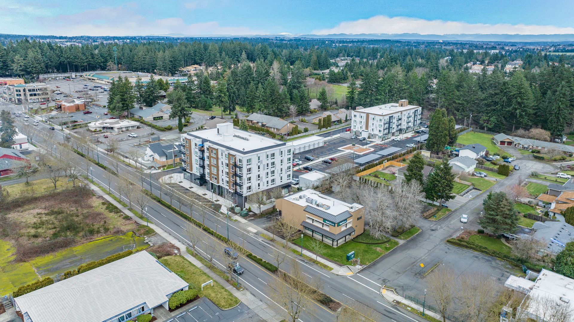 An aerial view of a city with a large building in the middle of it.