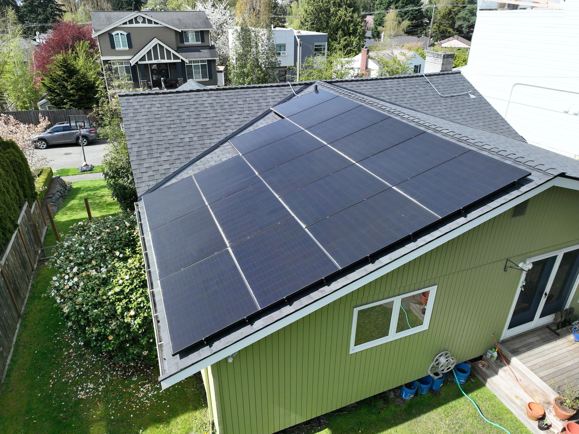 A green house with solar panels on the roof.