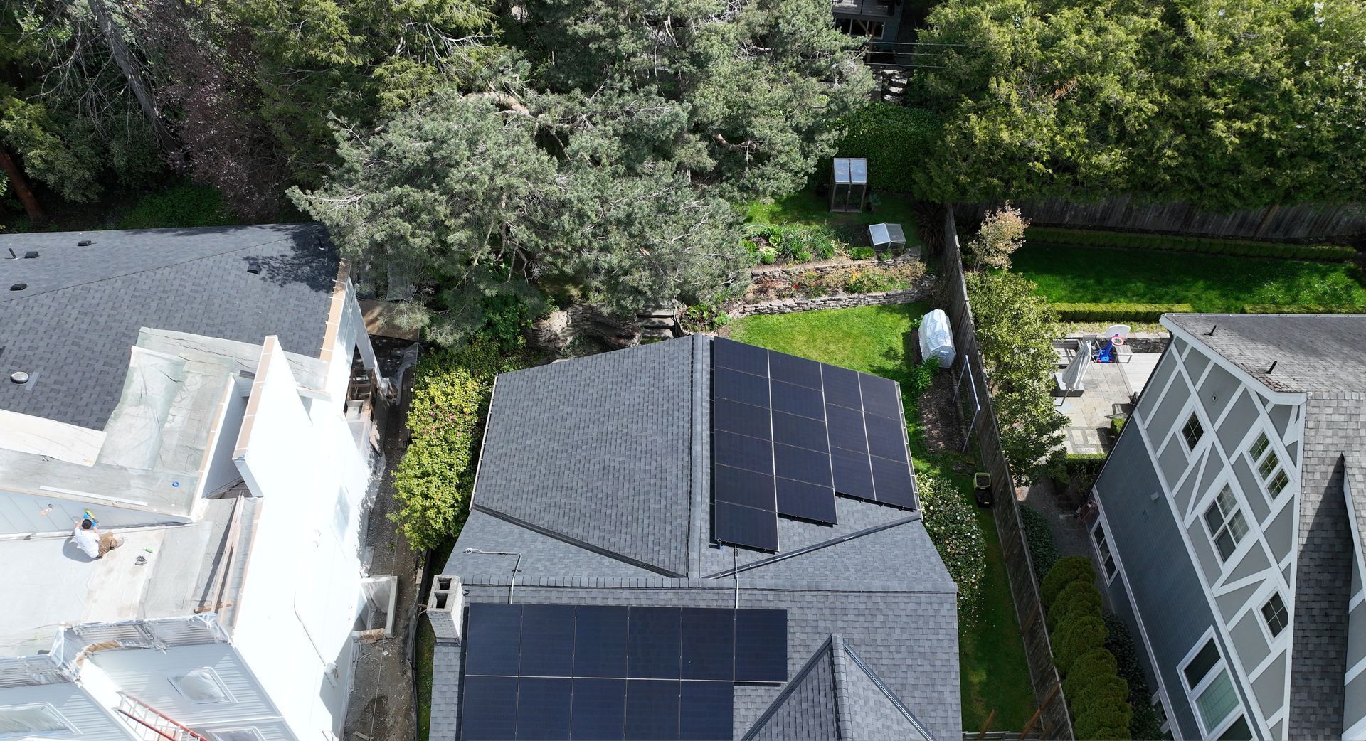 An aerial view of a house with solar panels on the roof.
