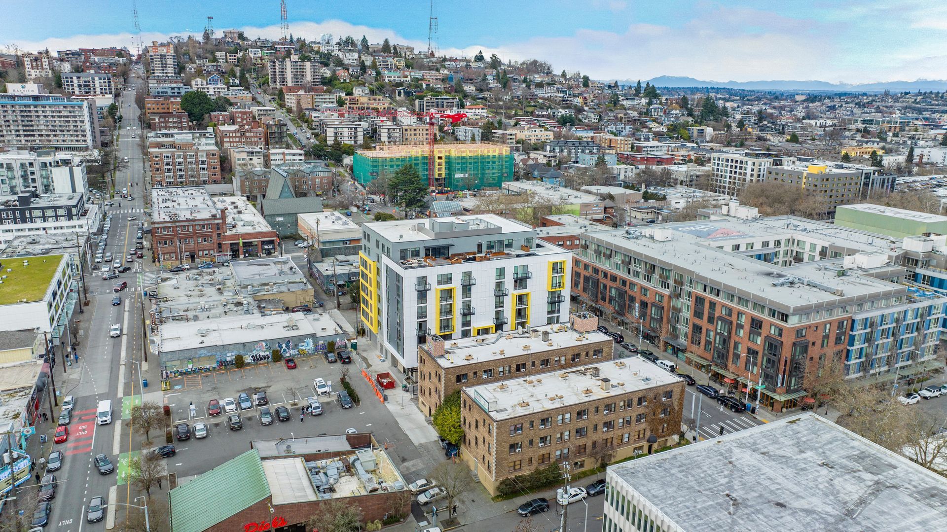 An aerial view of a city with a lot of buildings and a hill in the background.