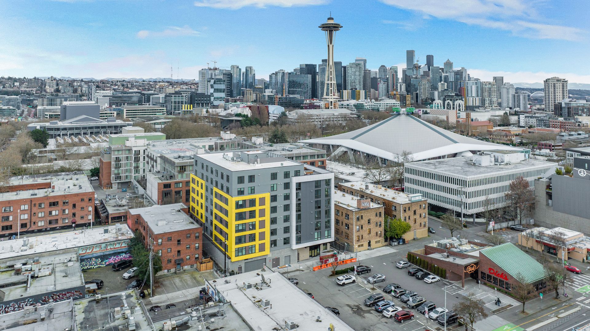 An aerial view of a city with a yellow building in the middle of it.