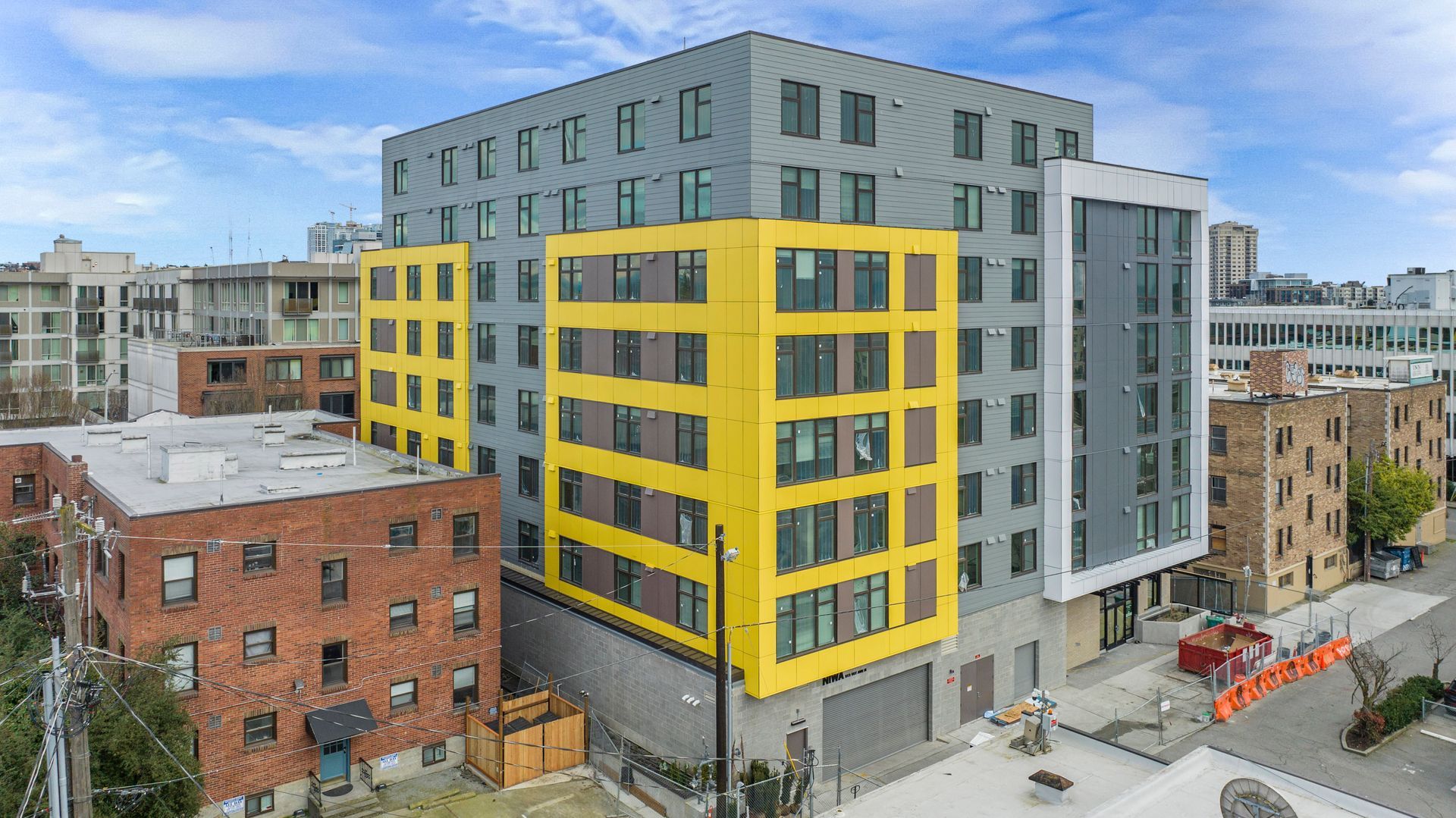 An aerial view of a large building with a yellow facade in a city.