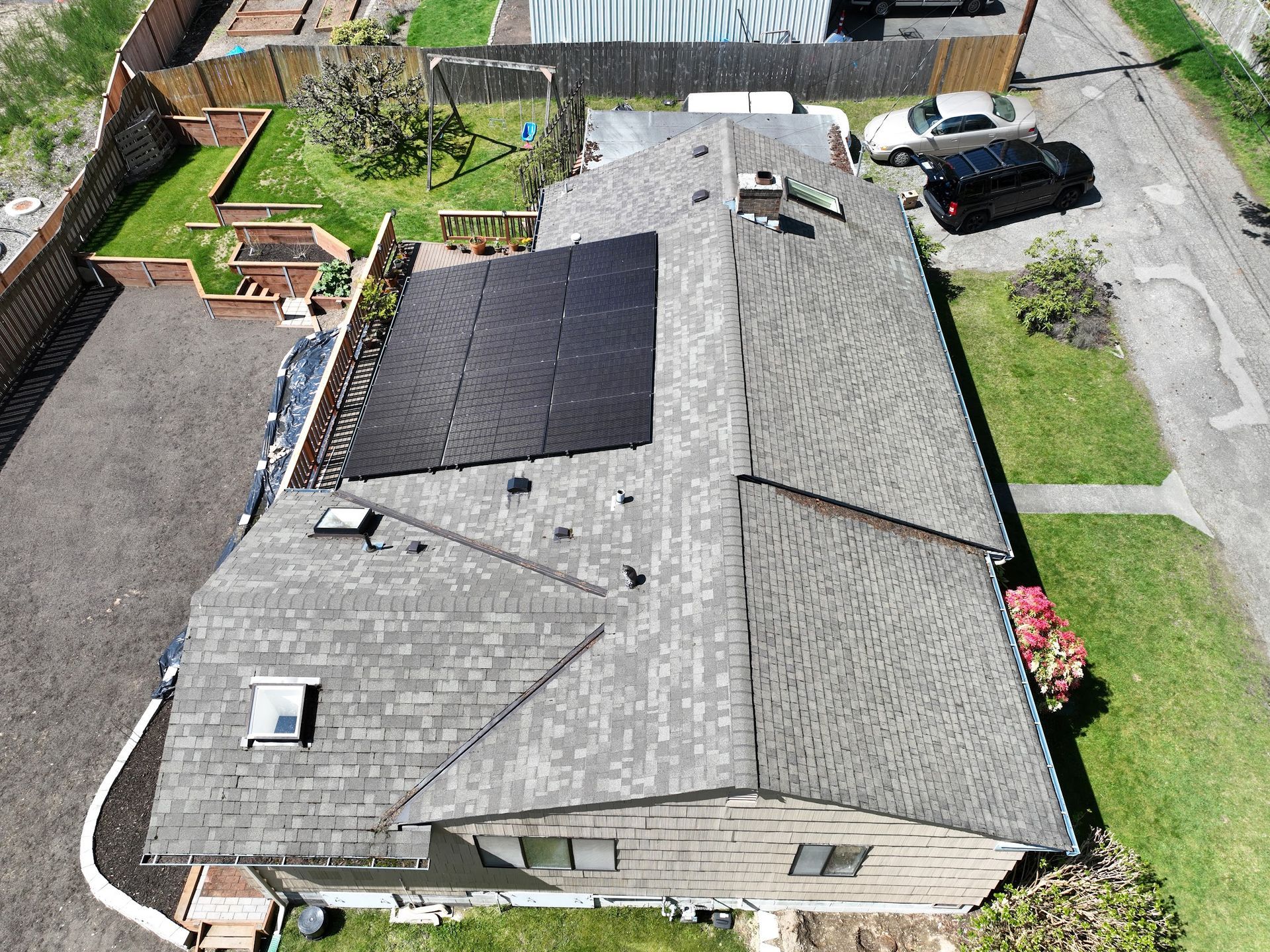 An aerial view of a house with solar panels on the roof.