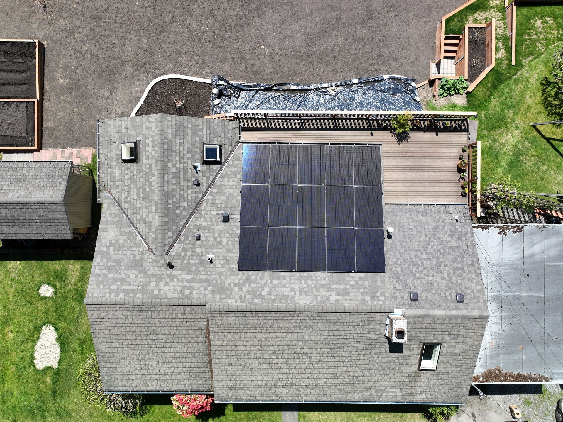An aerial view of a house with solar panels on the roof.