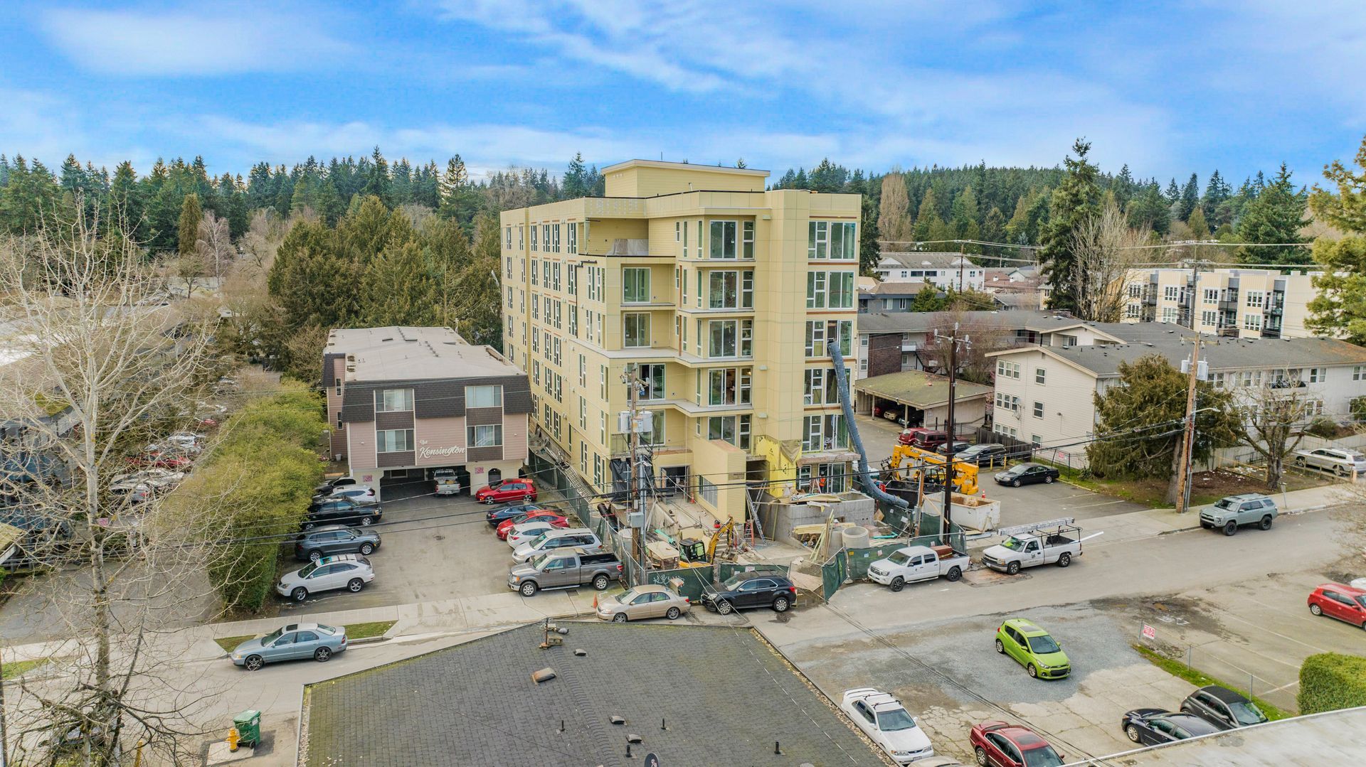 An aerial view of a building with a lot of cars parked in front of it.