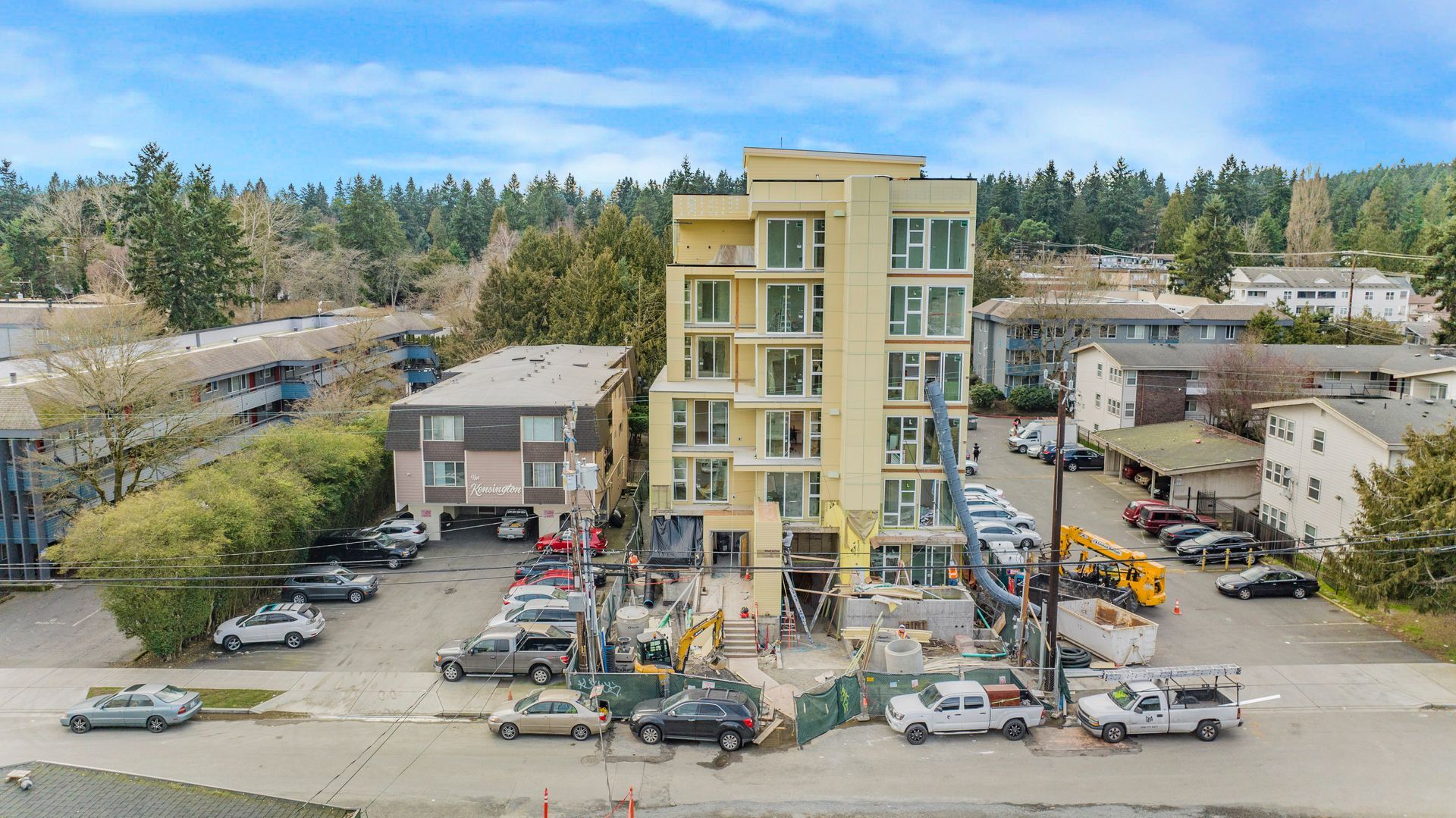 An aerial view of a building under construction with cars parked in front of it.