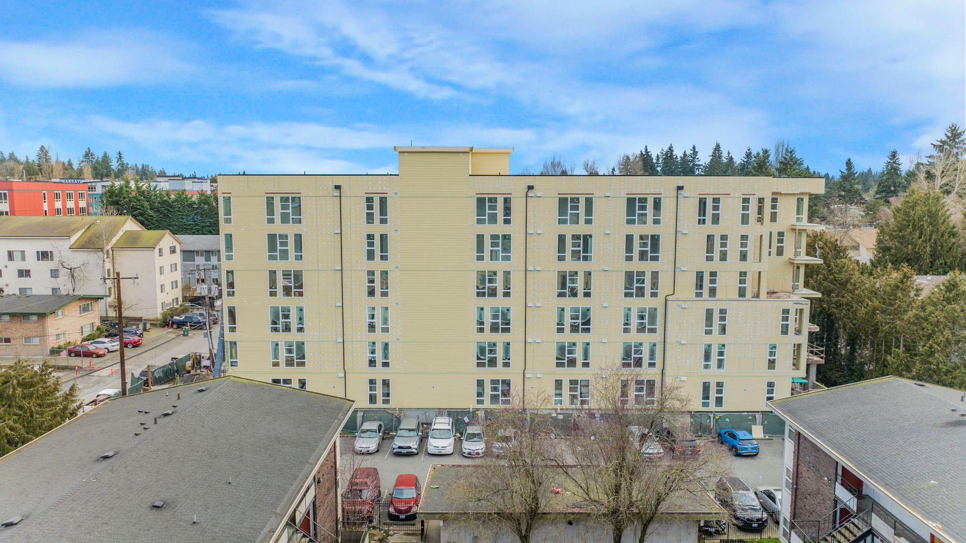 An aerial view of a large building with cars parked in front of it.