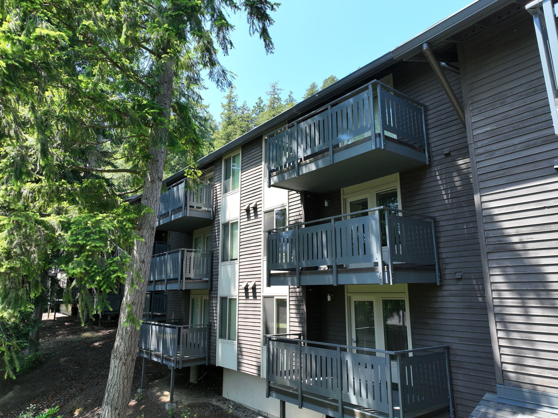 A building with a lot of balconies and trees in the background