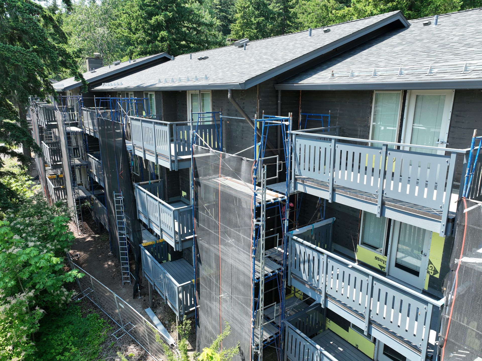 A large apartment building is being remodeled with scaffolding and balconies.