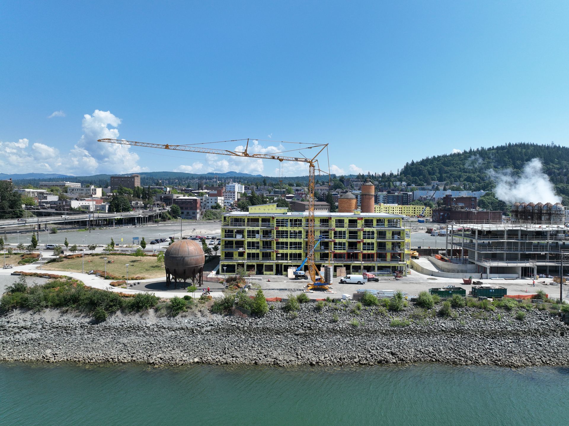An aerial view of a building under construction next to a body of water.