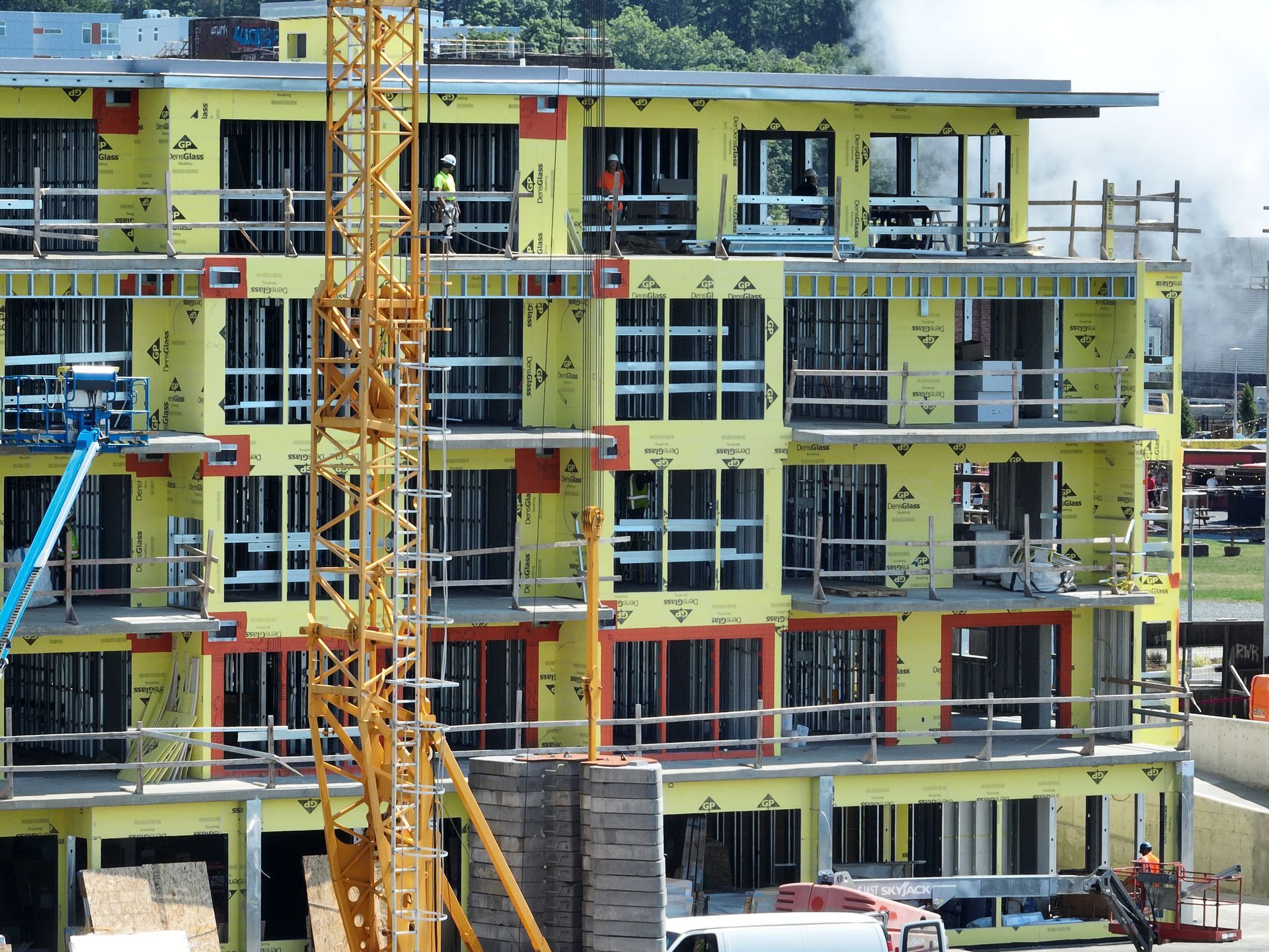A large building under construction with a crane in front of it