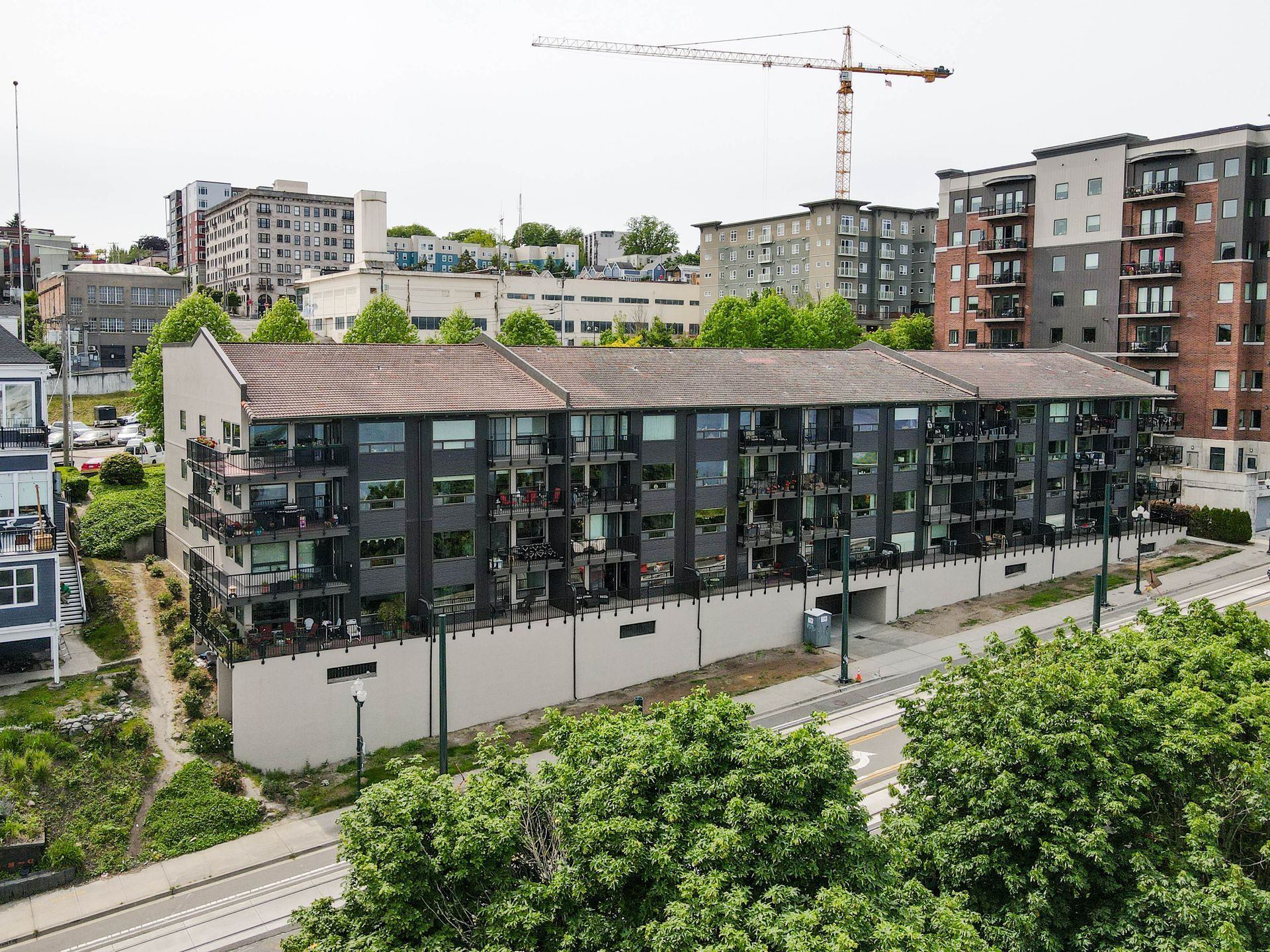 An aerial view of a large apartment building with a crane in the background.