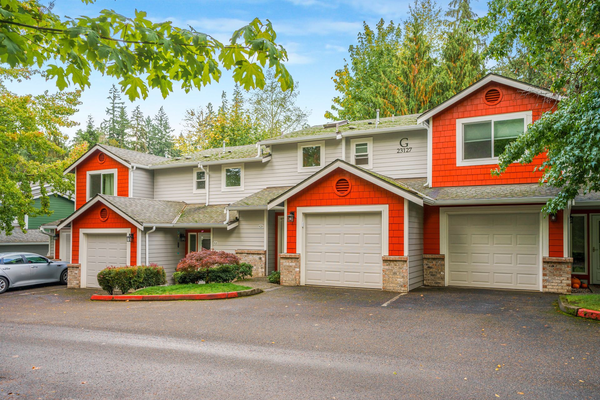 A red and white house with a car parked in front of it.
