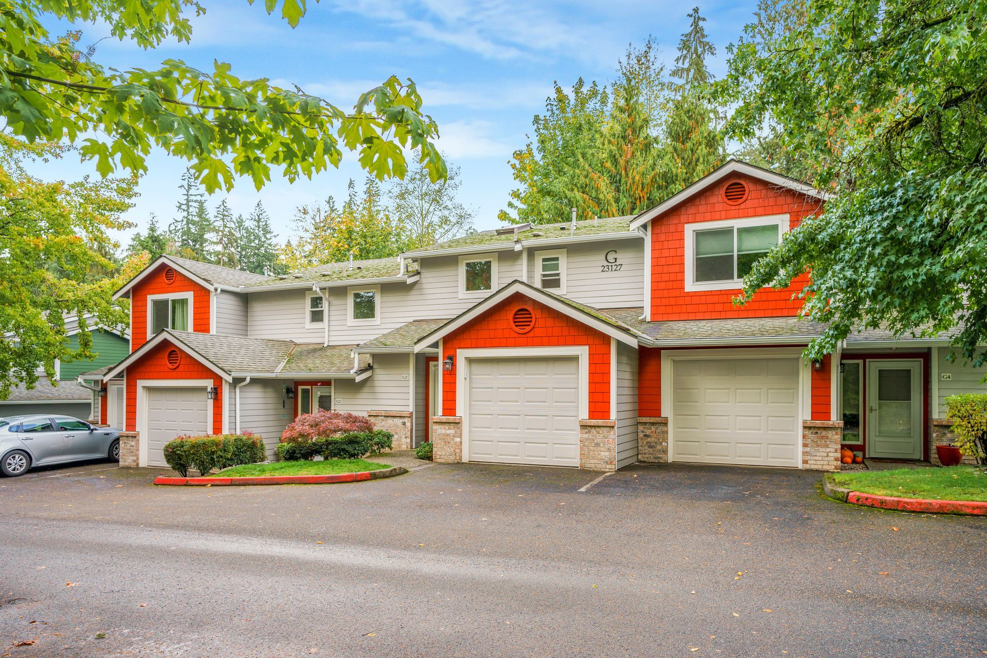A house with a red roof and white garage doors