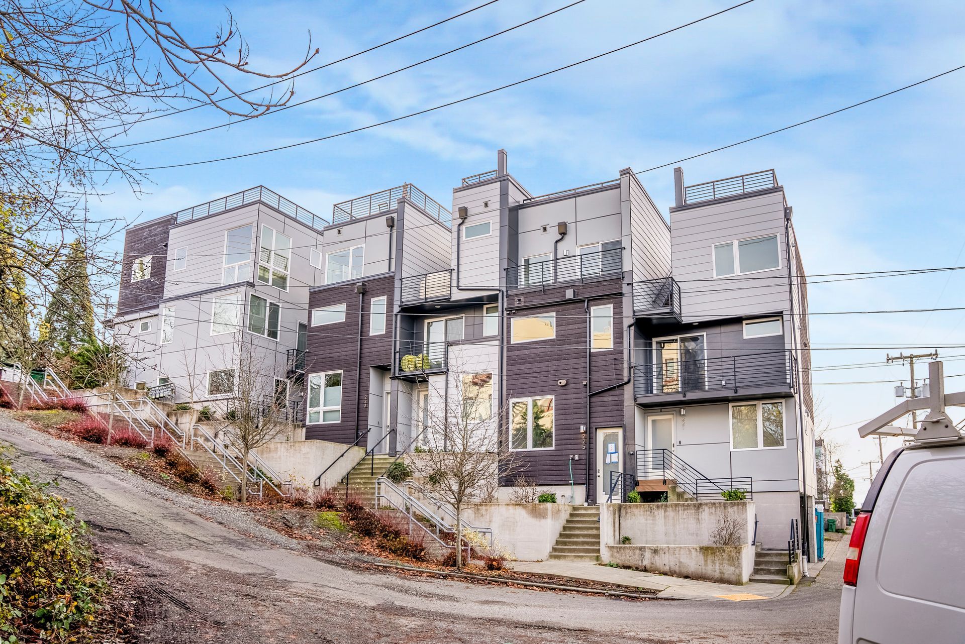 A building with a van parked in front of it on a hill.