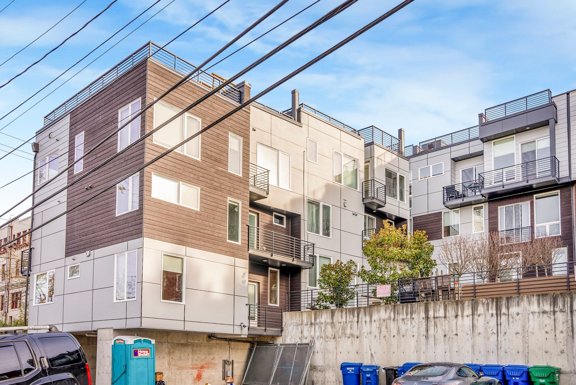 A large apartment building with a portable toilet in front of it.