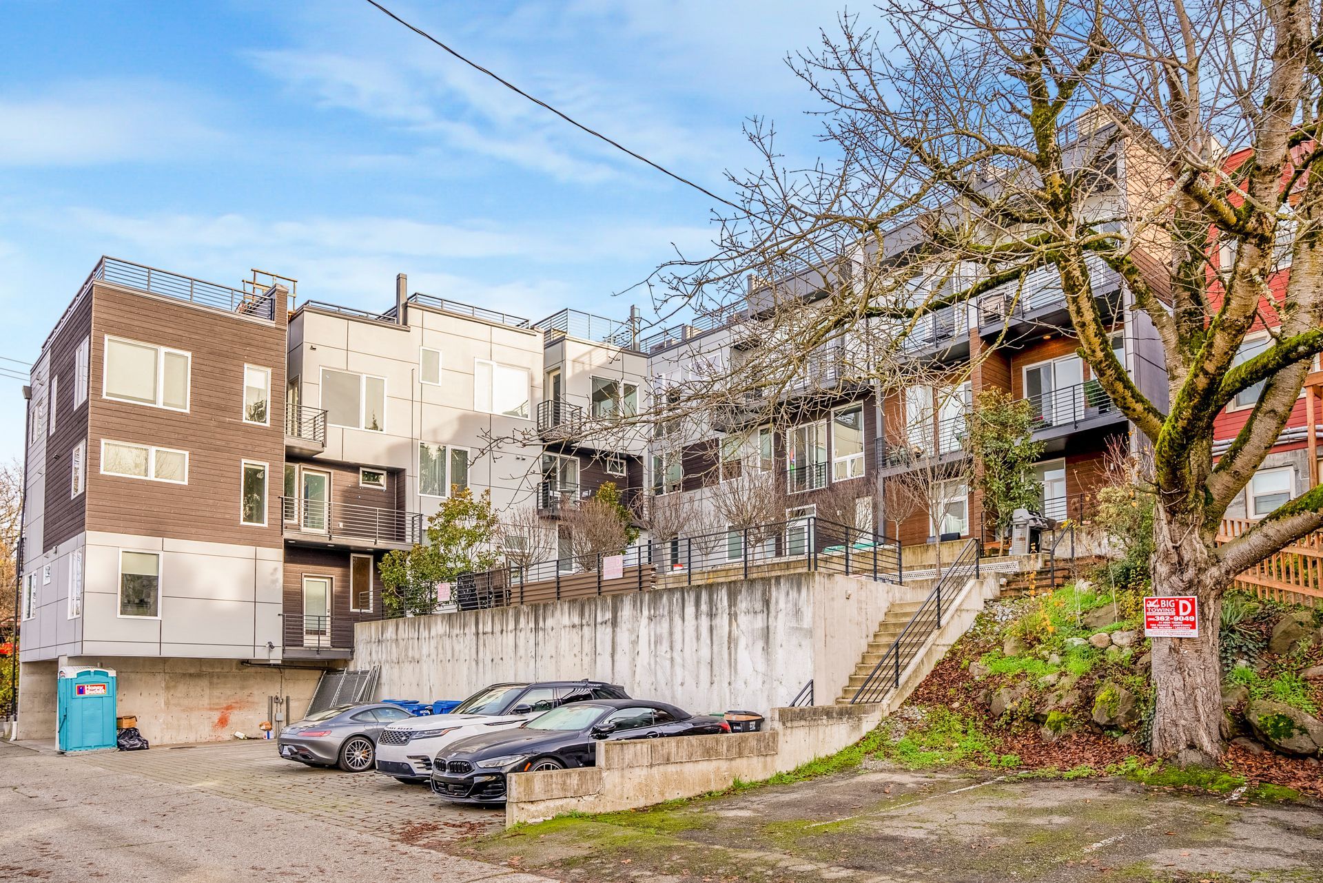A row of cars are parked in front of a building.