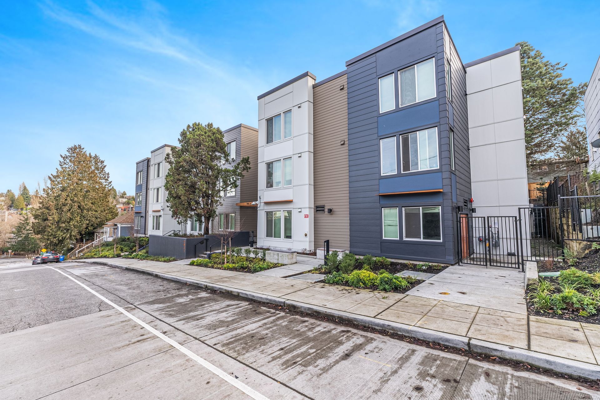 A row of apartment buildings are lined up next to each other on a sunny day.