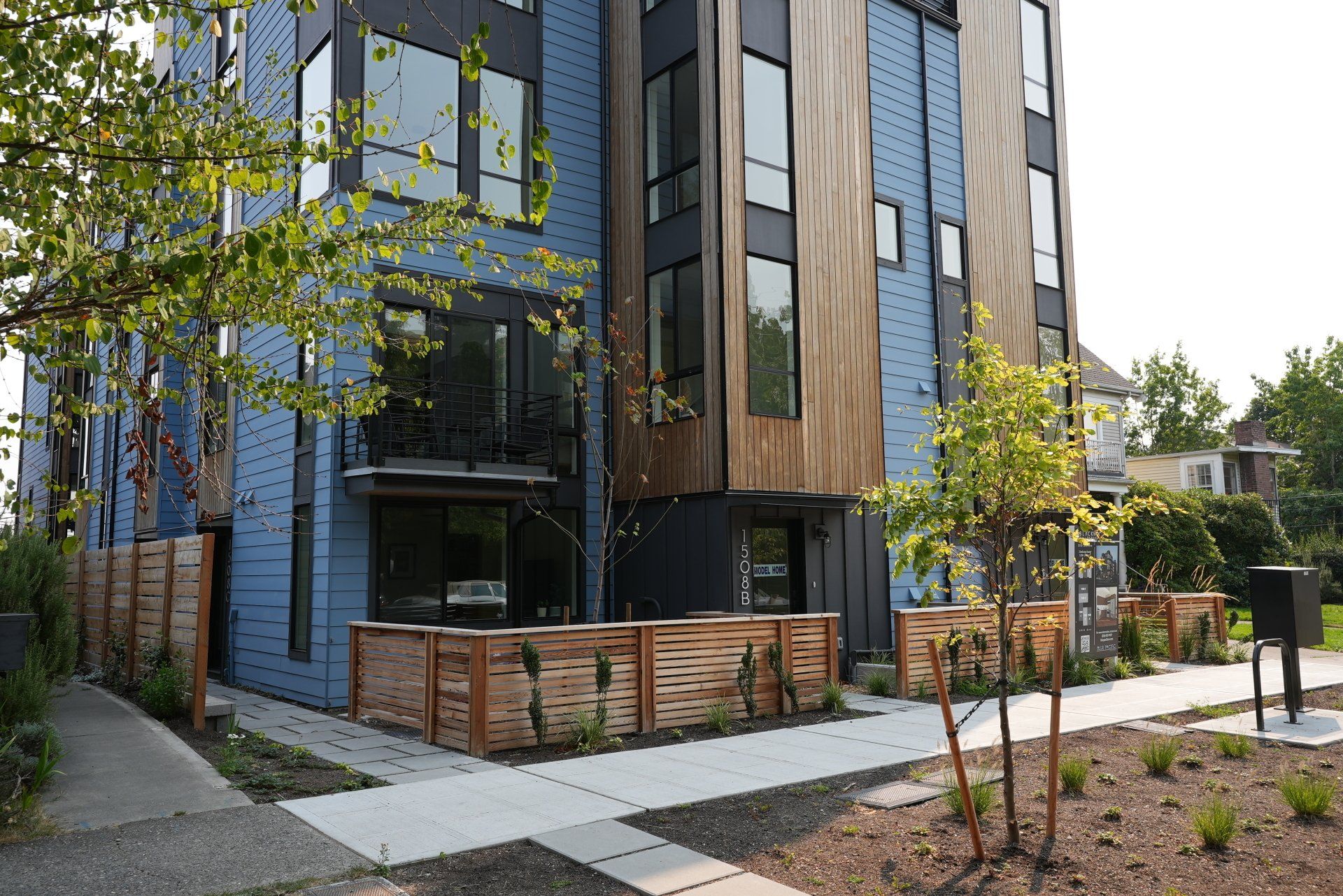 A large blue building with a lot of windows and trees in front of it.
