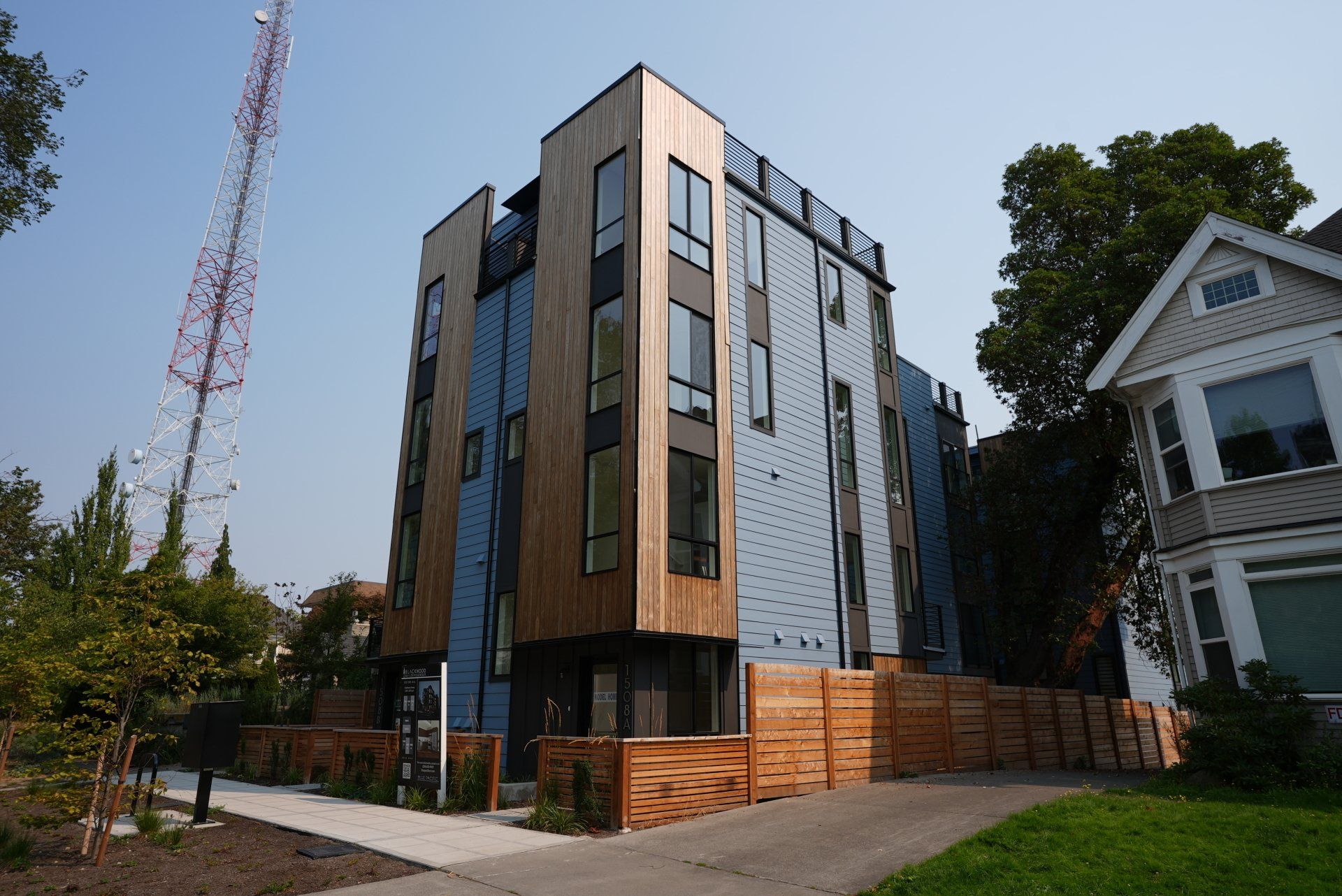 A large building with a lot of windows is sitting next to a house.