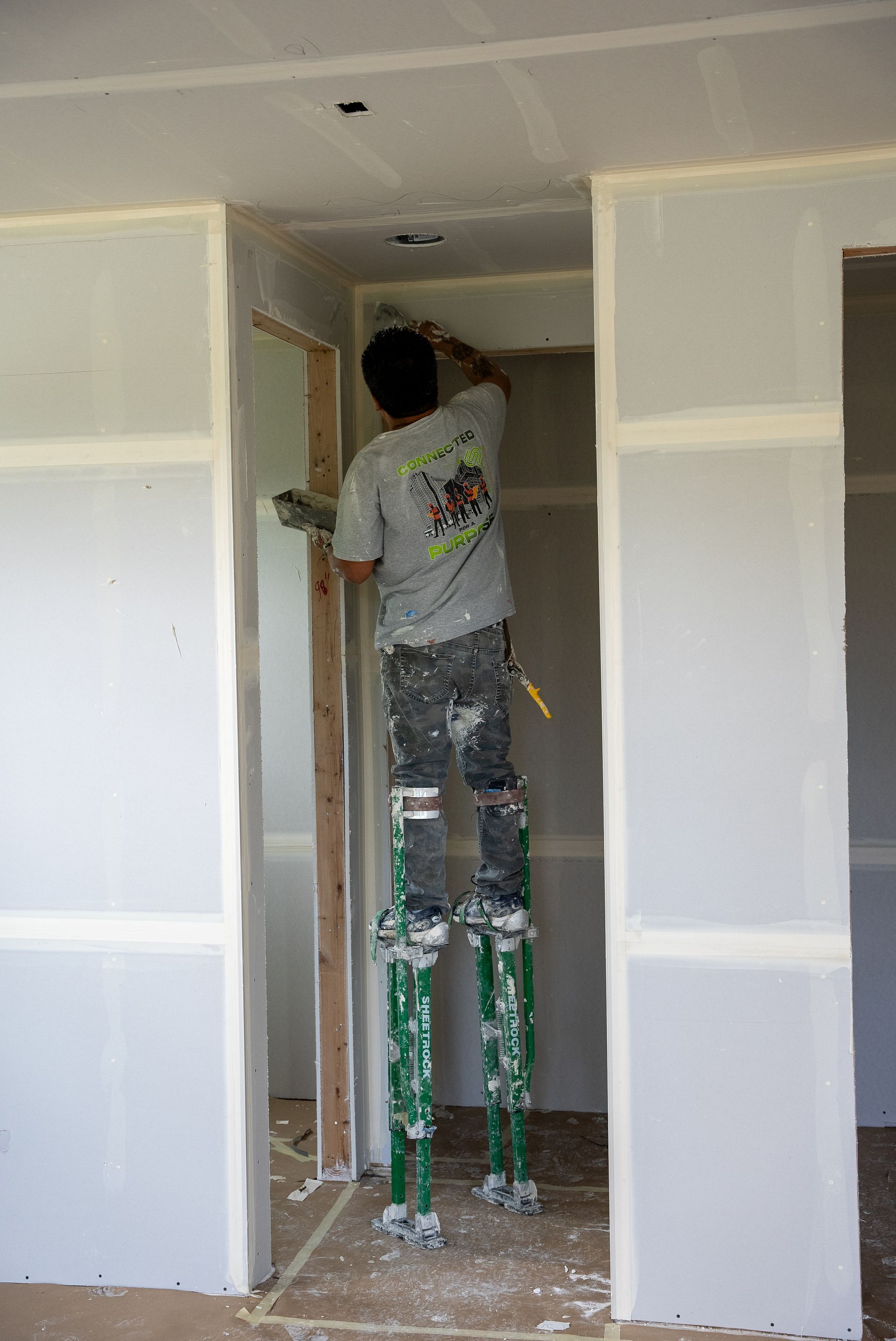 A man is standing on stilts in a room.