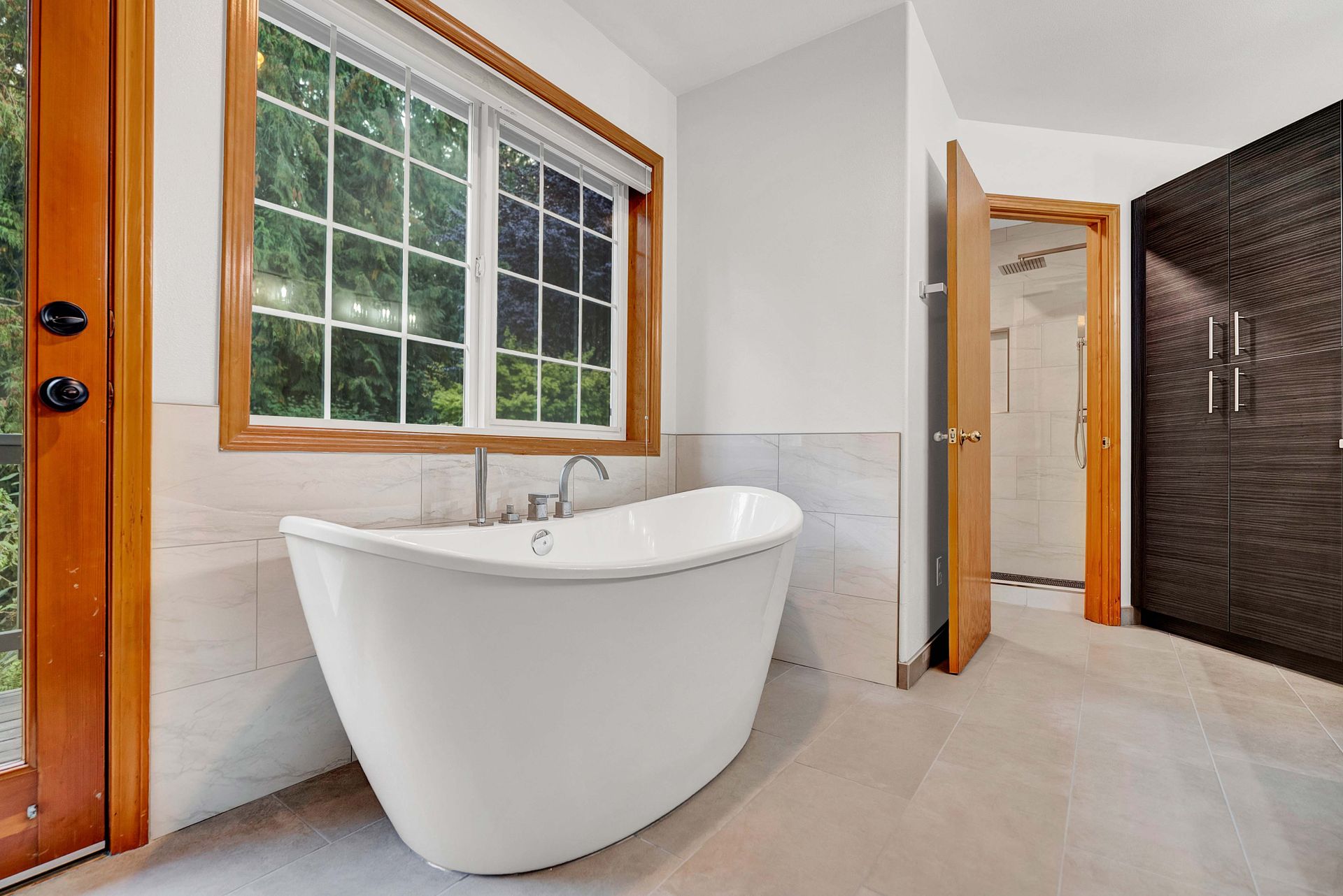There is a bathtub in the middle of the bathroom next to a window.
