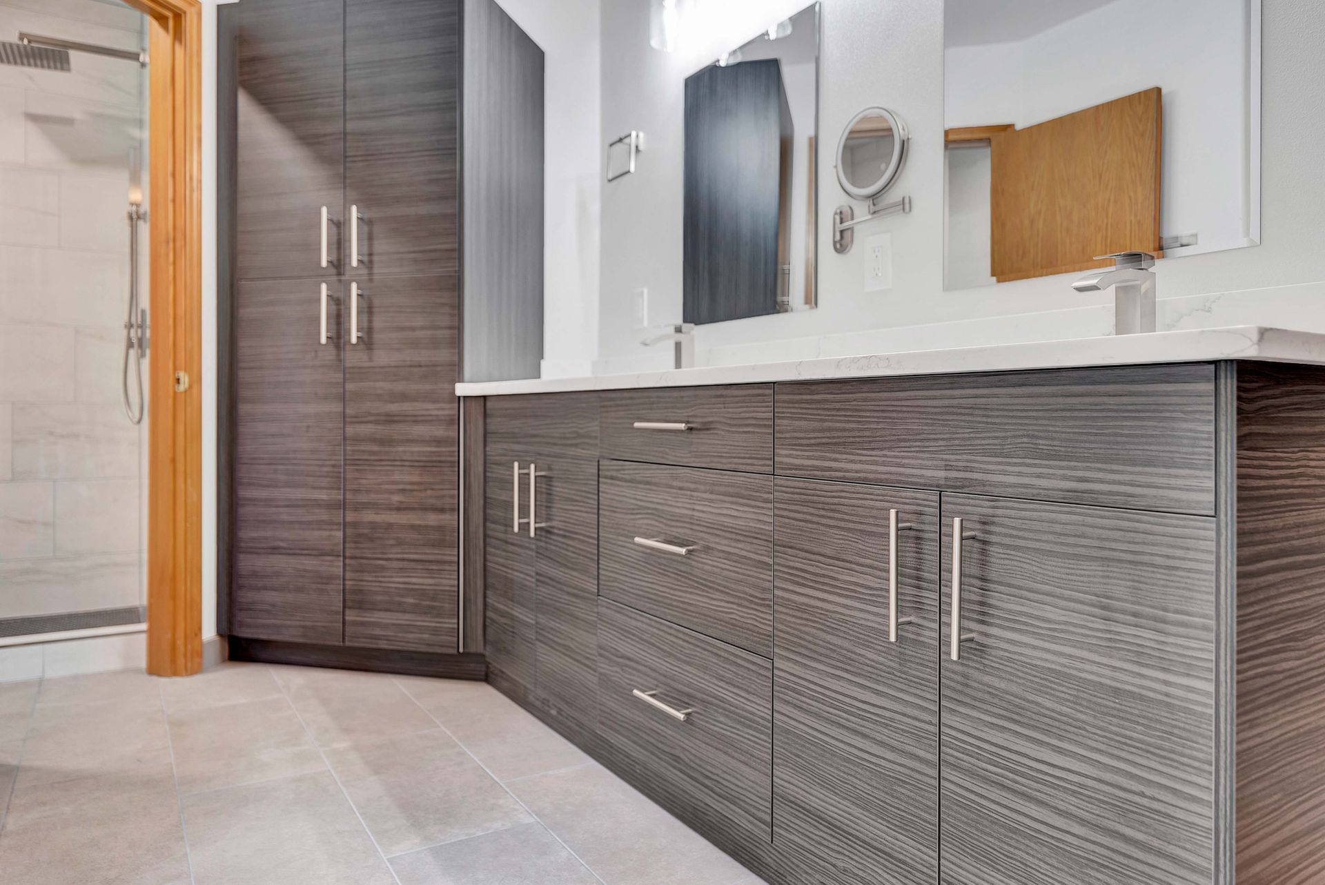 A bathroom with two sinks , a mirror , and a walk in shower.