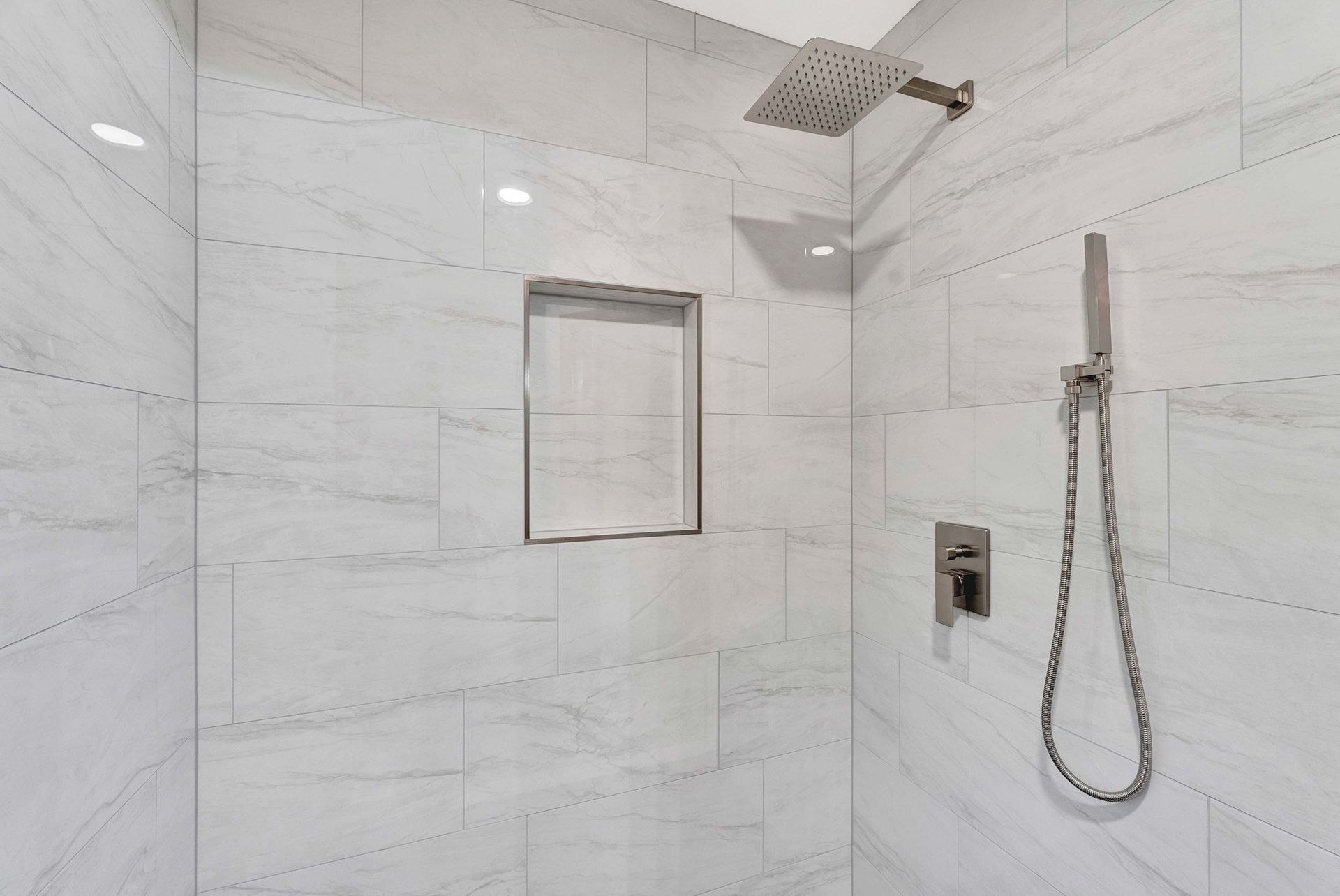 A shower with a shower head and a shower head in a bathroom.
