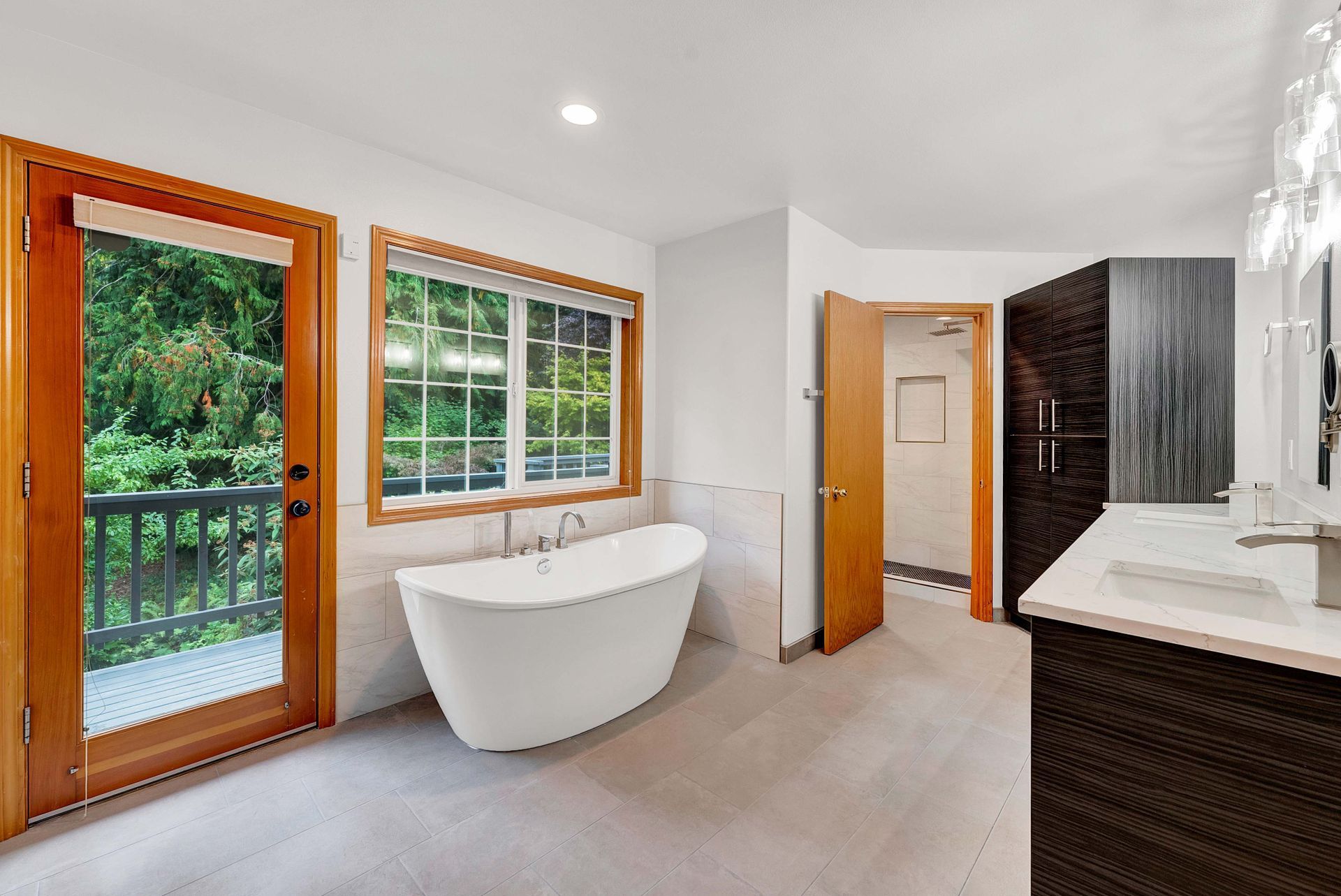 A bathroom with a tub , sink , and window.