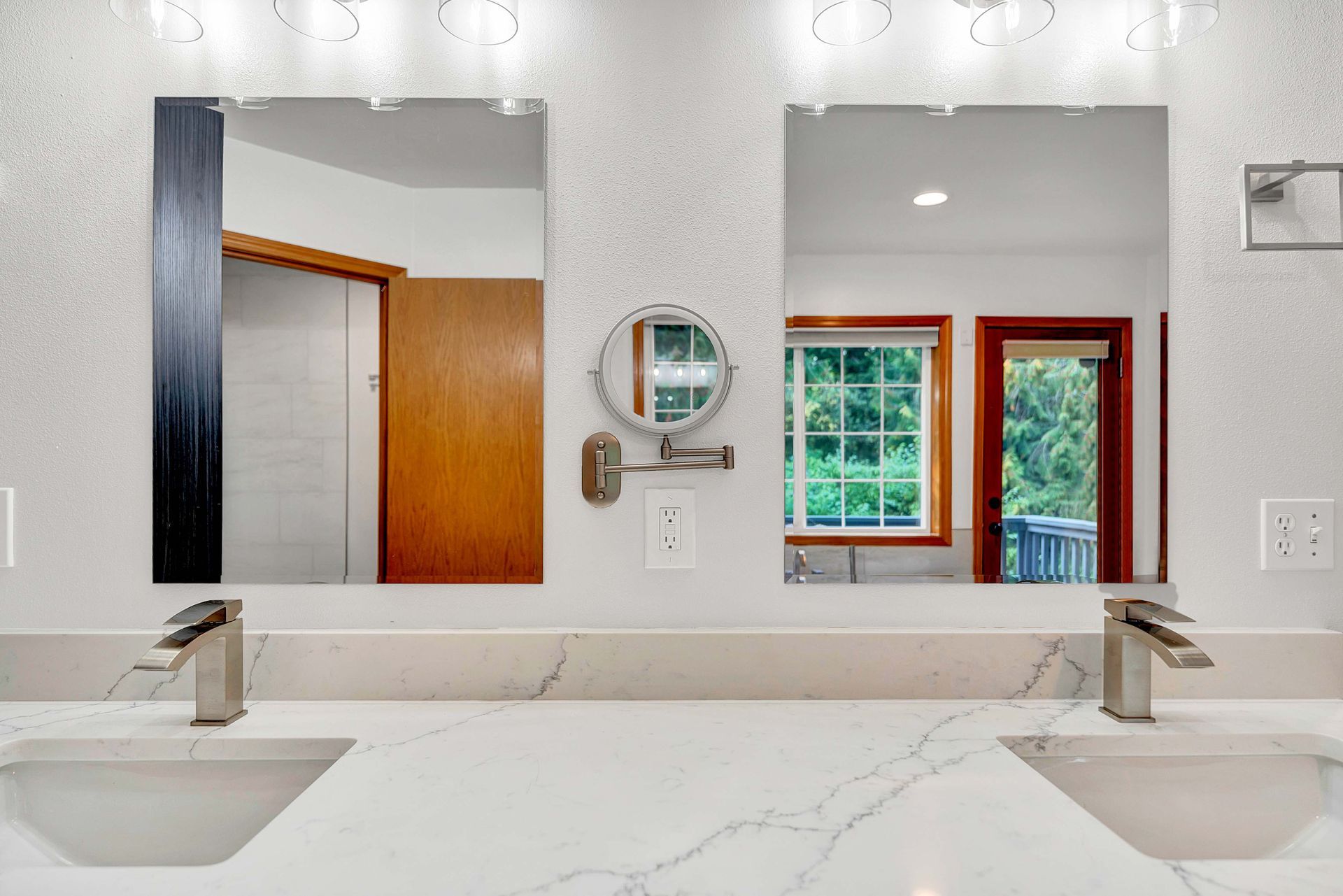 A bathroom with two sinks and two mirrors.