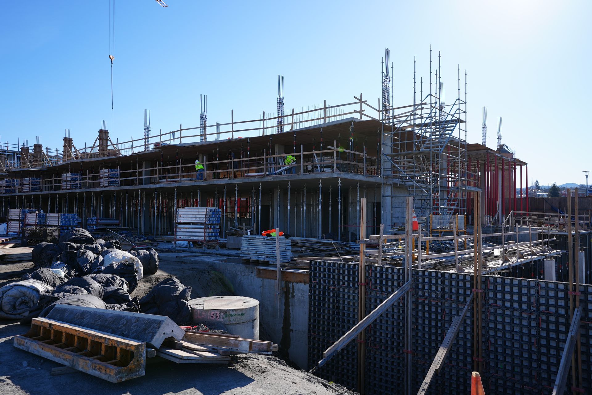 A large building is being built with scaffolding and a crane.