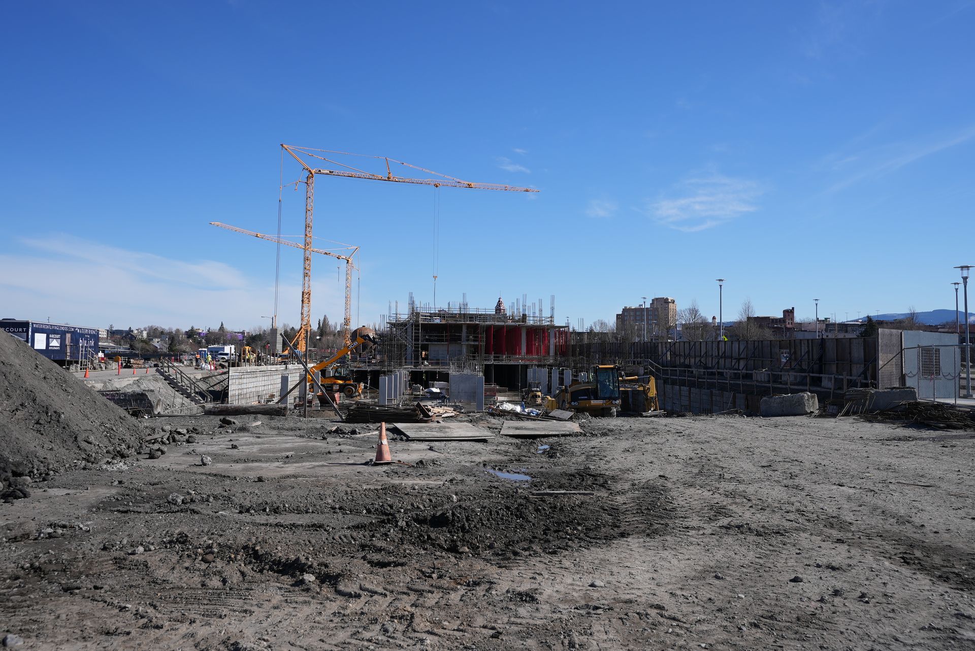 A construction site with a lot of cranes in the background.